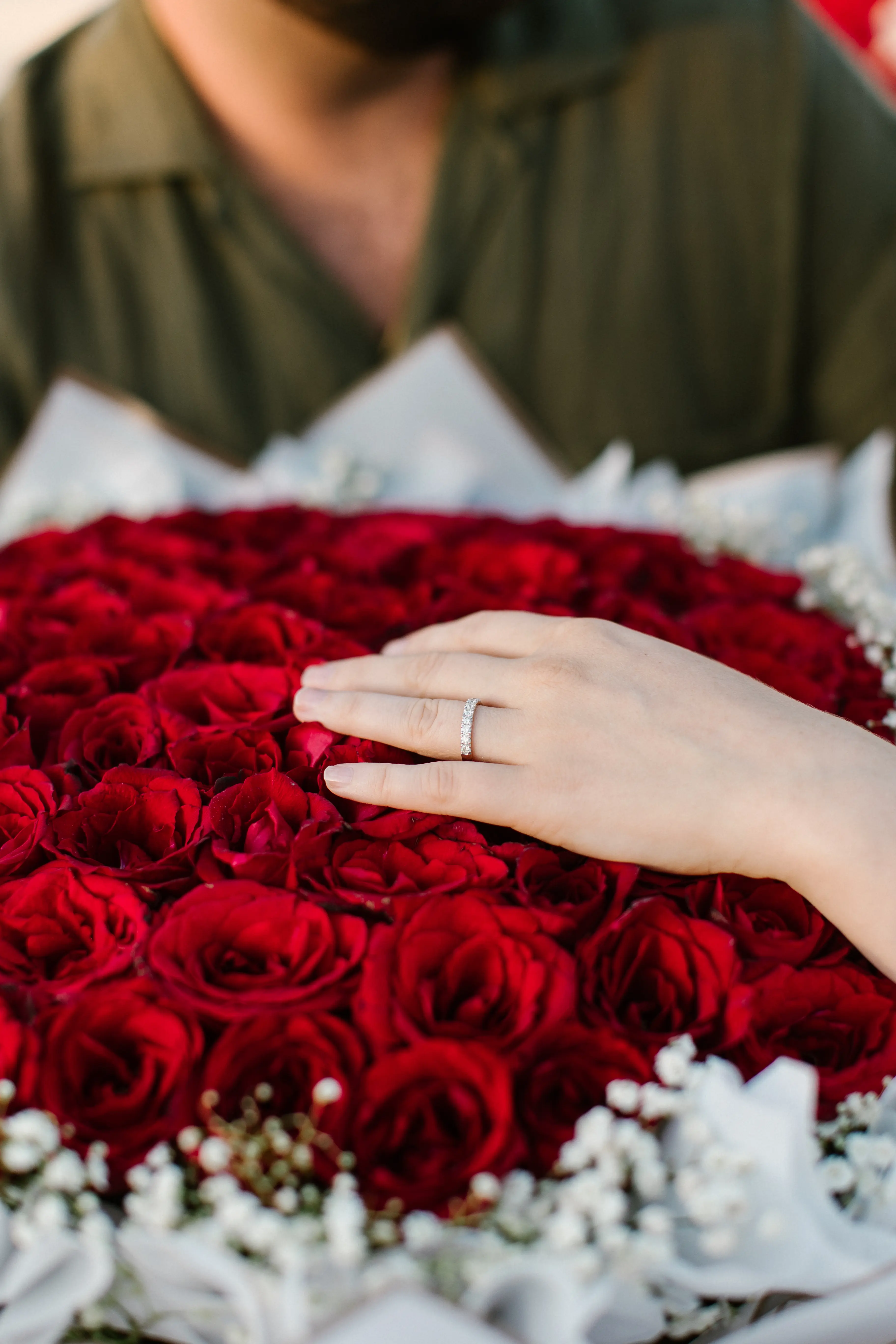 Close-up of engagement ring surrounded by red roses during Bali proposal