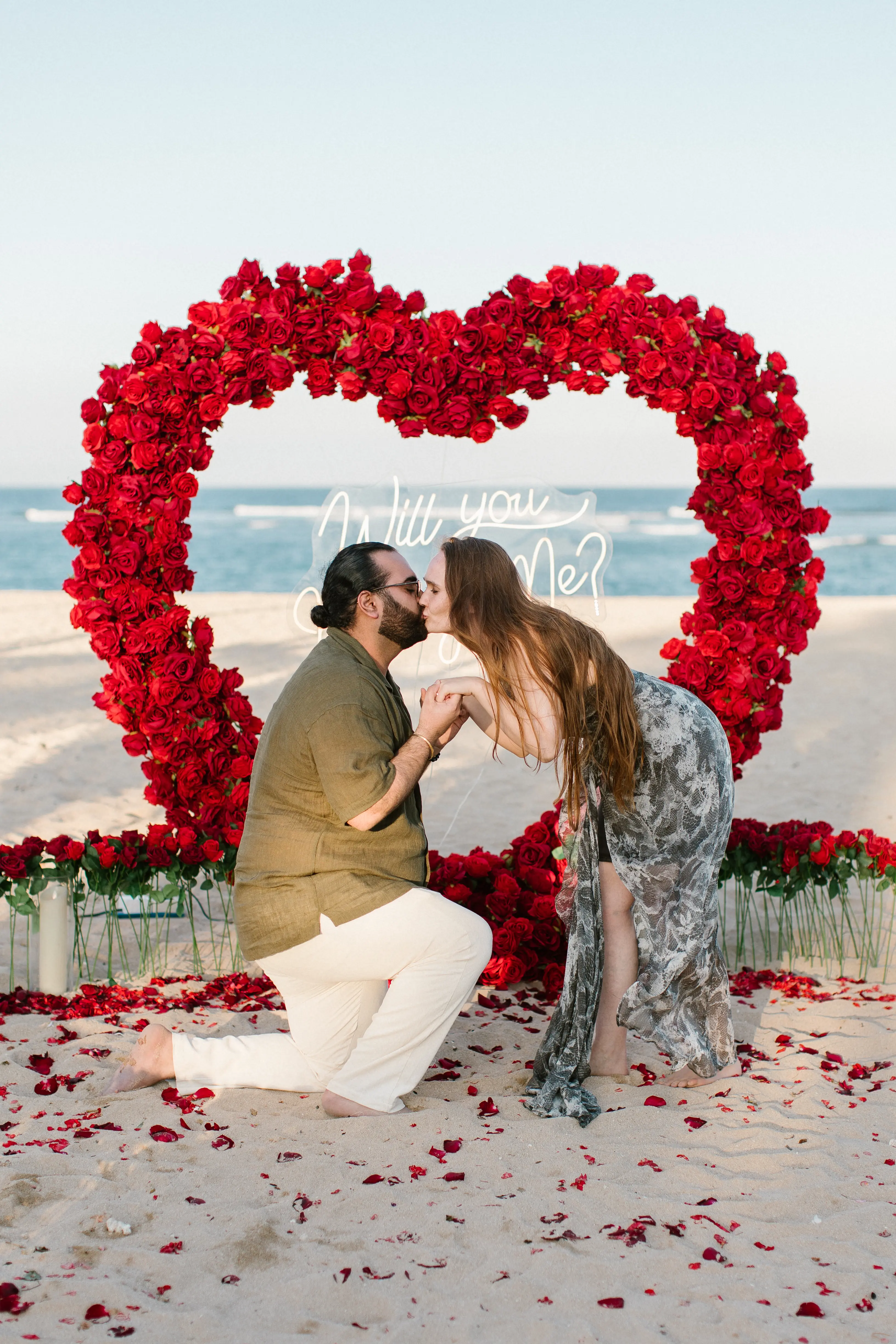 Couple posing inside heart-shaped flower arch during engagement in Bali