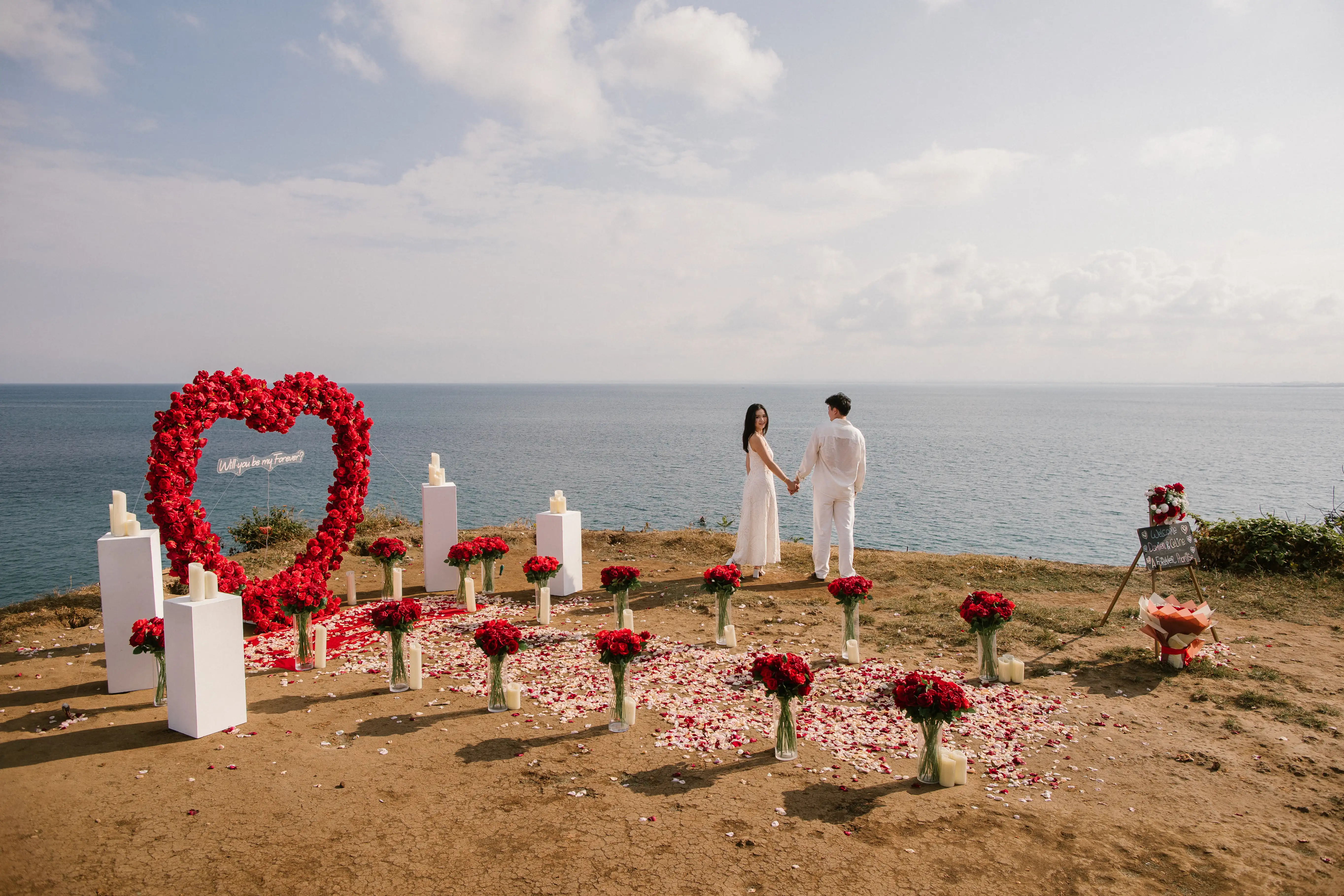Cliffside proposal decoration in Bali with flowers and candle aisle