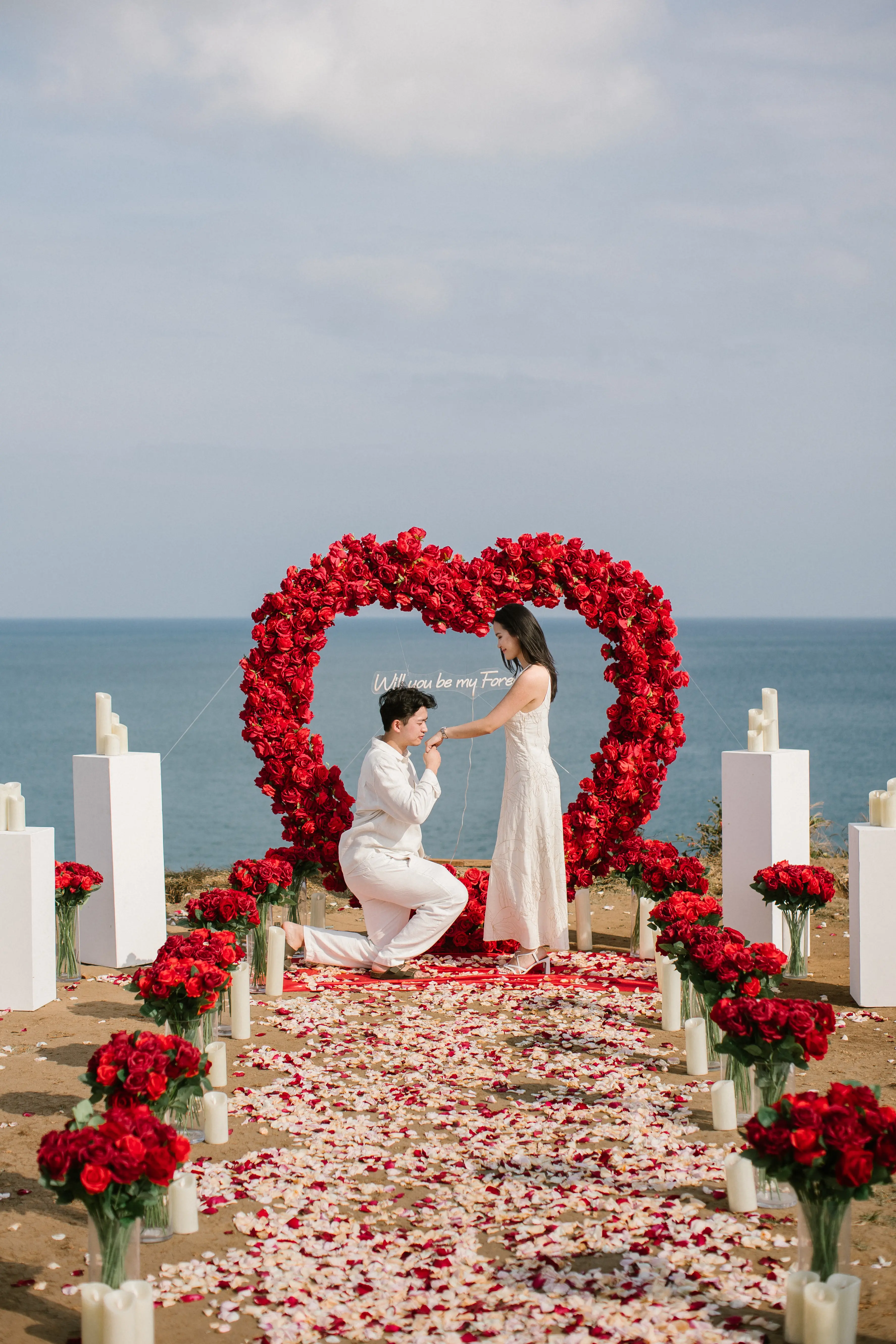 Bali cliff proposal with ocean backdrop and floral arch setup