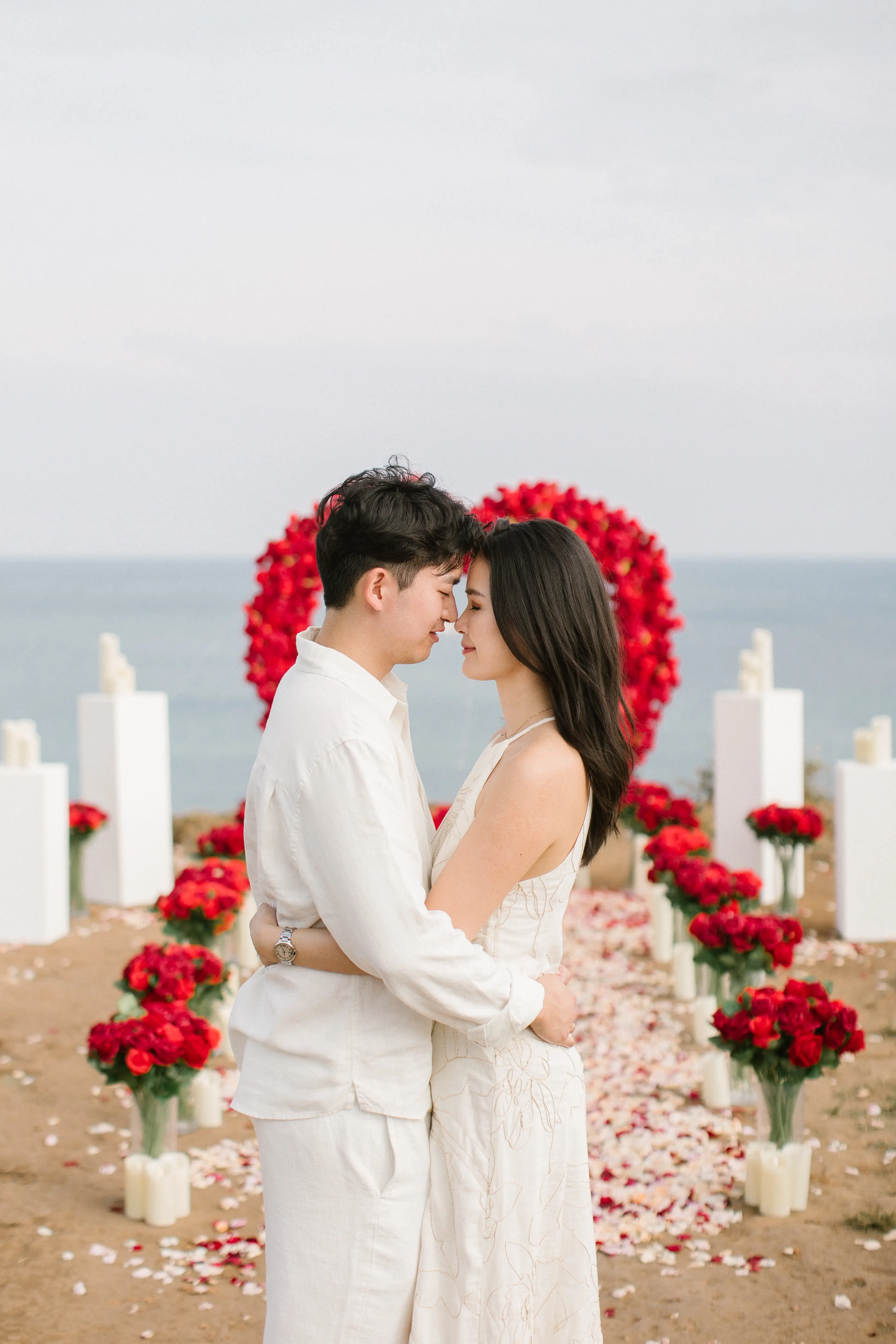 Romantic Bali cliffside proposal with red roses and sunset light
