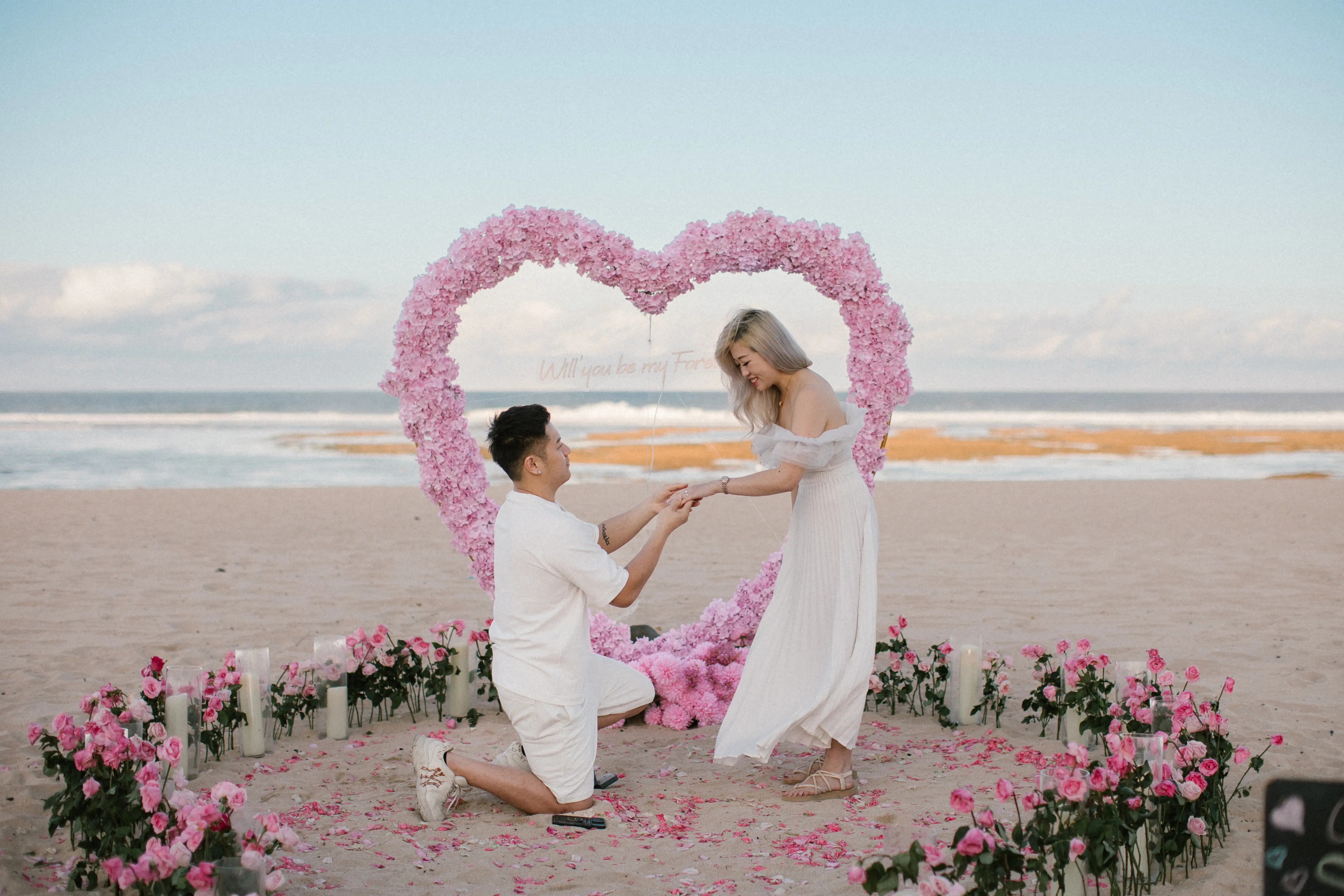 Marriage proposal in Bali with roses and ocean backdrop