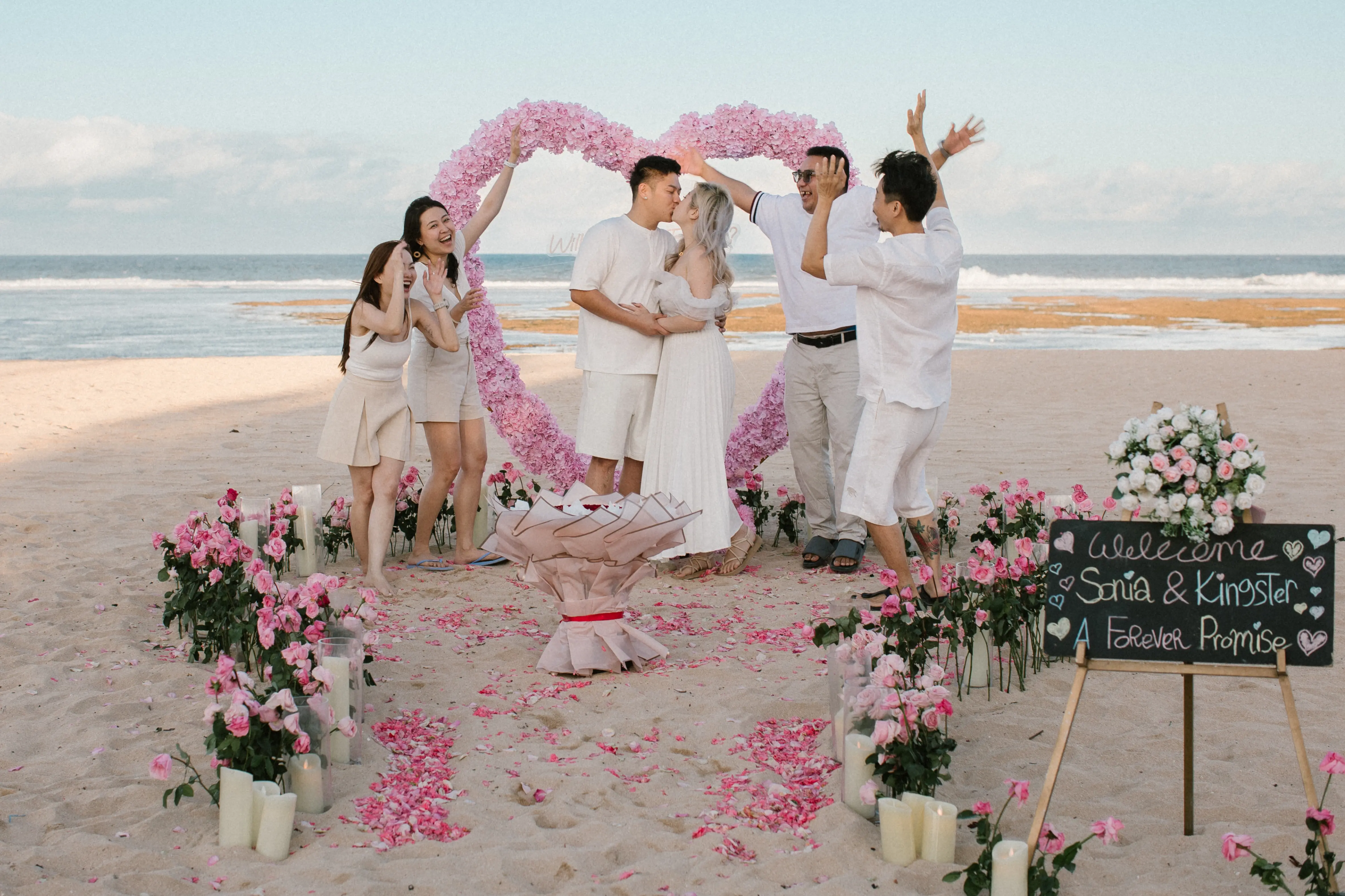 Marriage proposal on Bali beach with flowers and candlelight
