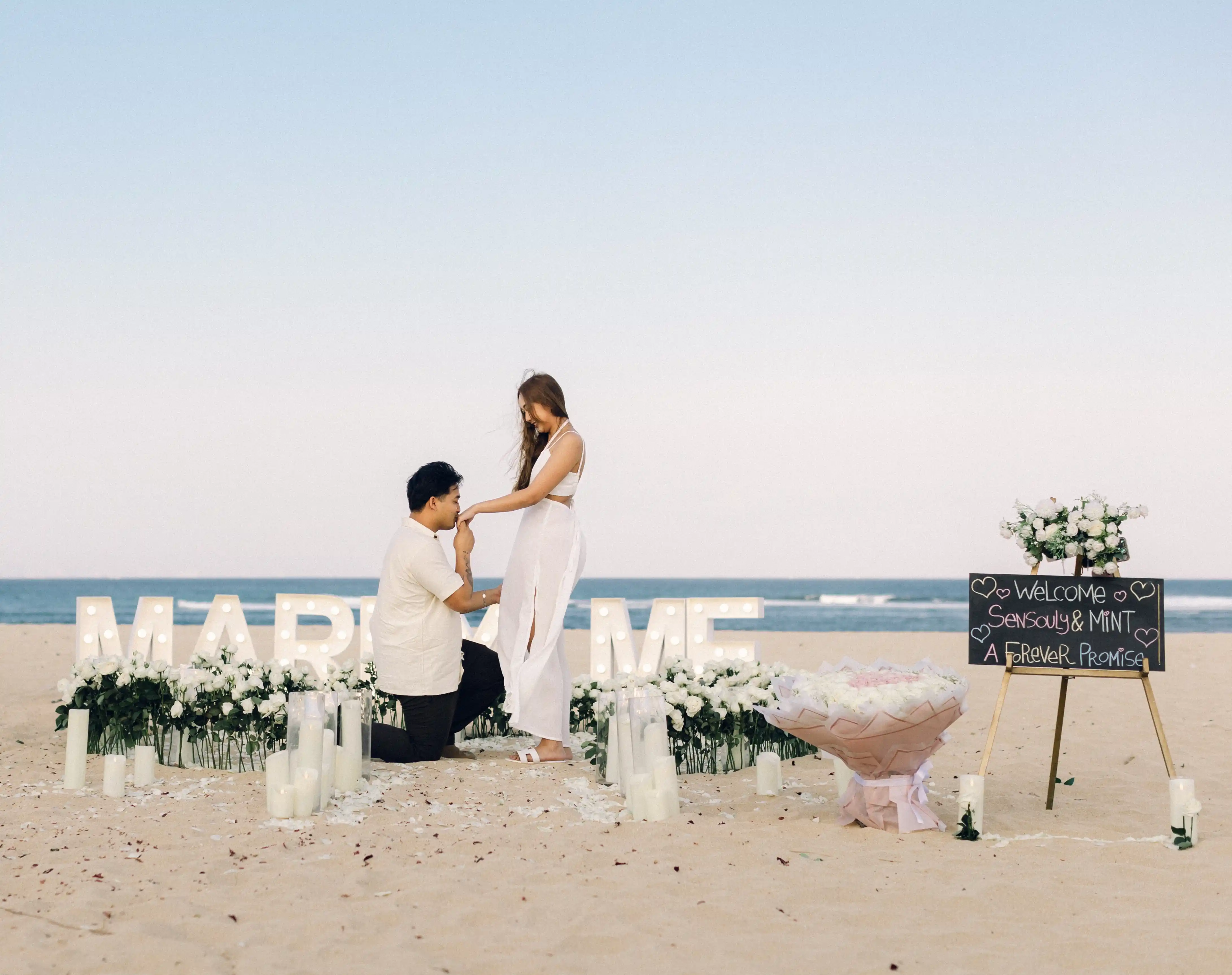 Romantic beach proposal in Bali with "Marry Me" sign