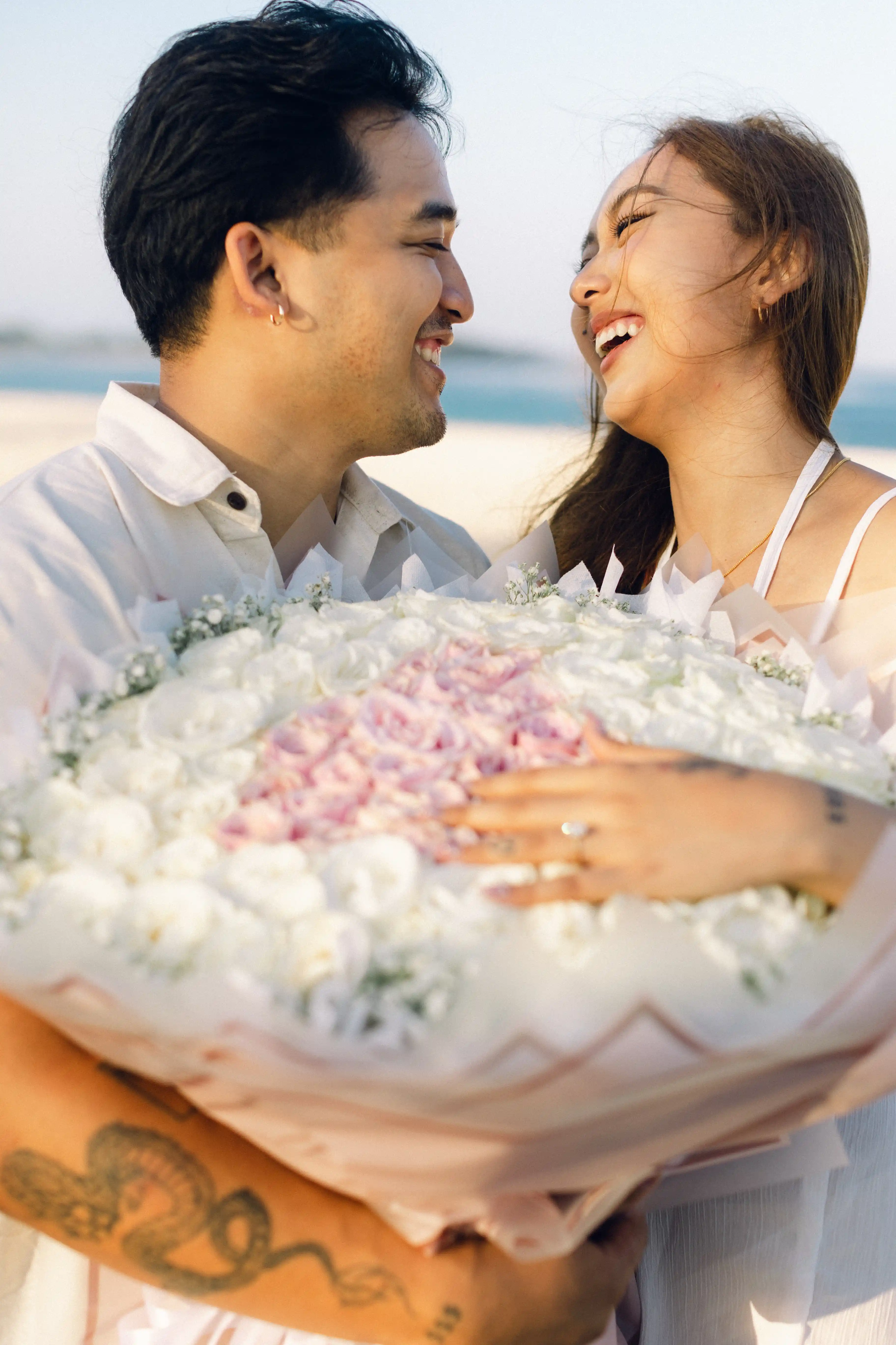 Couple smiling after beach engagement