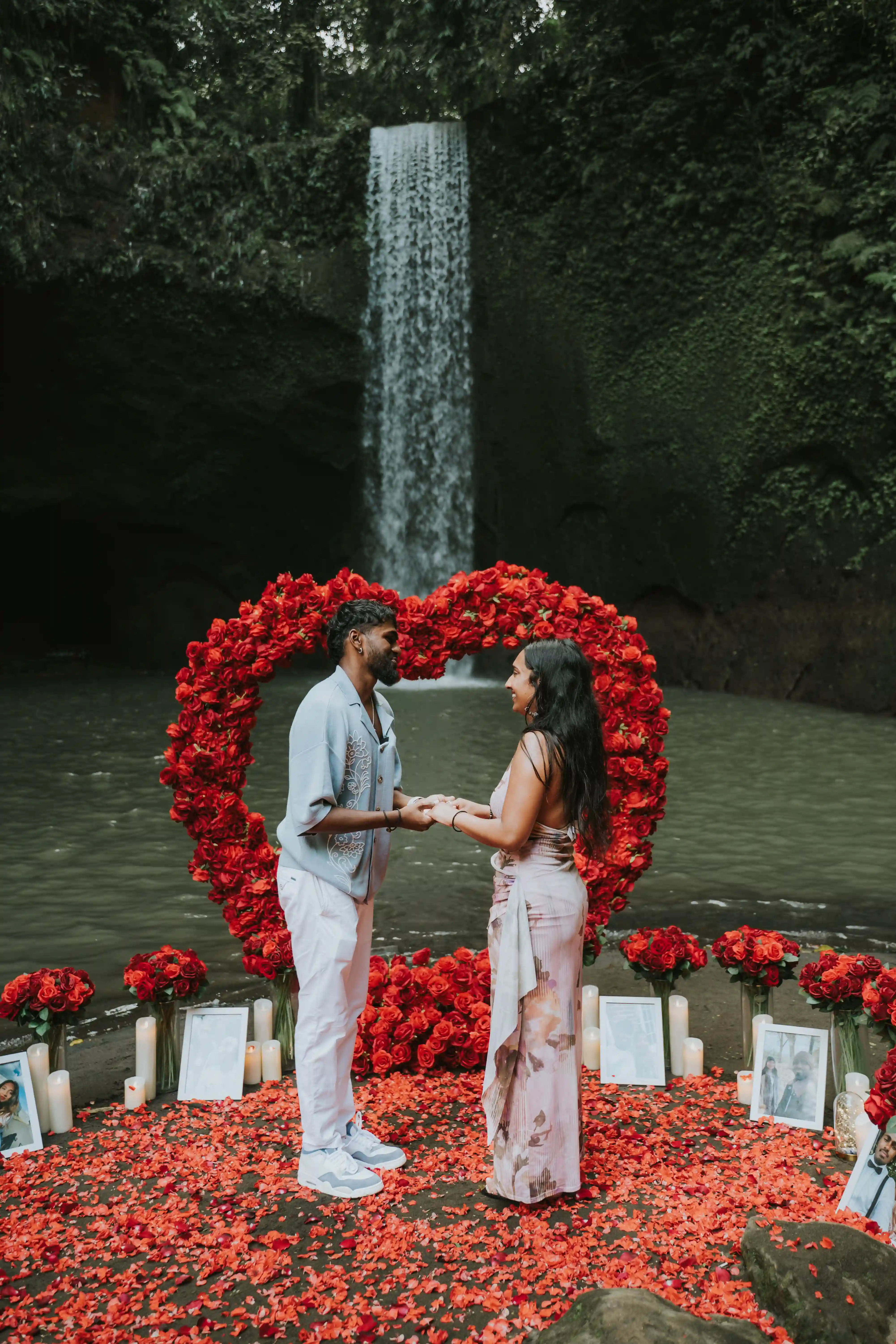 Scenic waterfall proposal setup in Bali with red roses