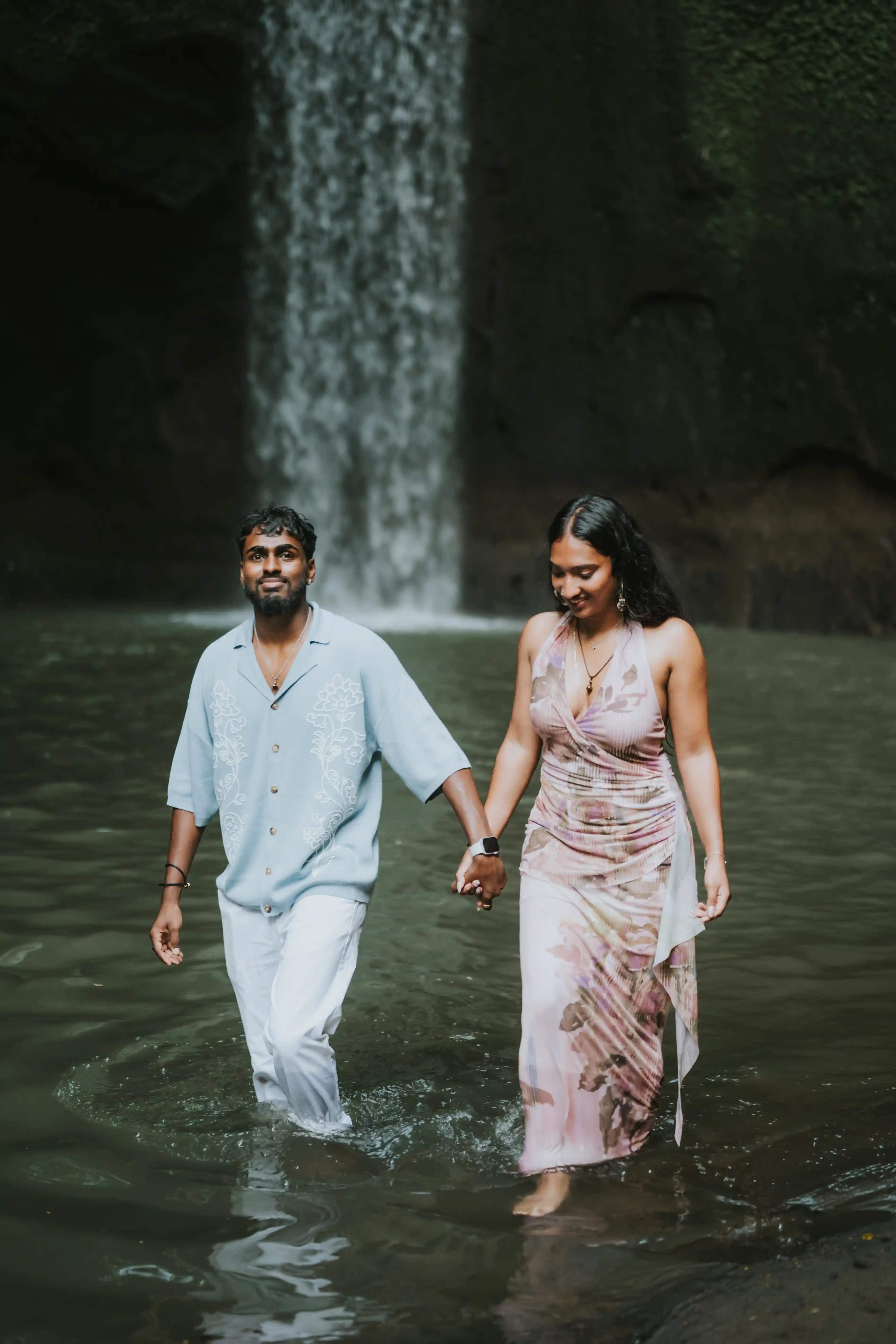 Couple walking hand in hand after proposal in Bali waterfall