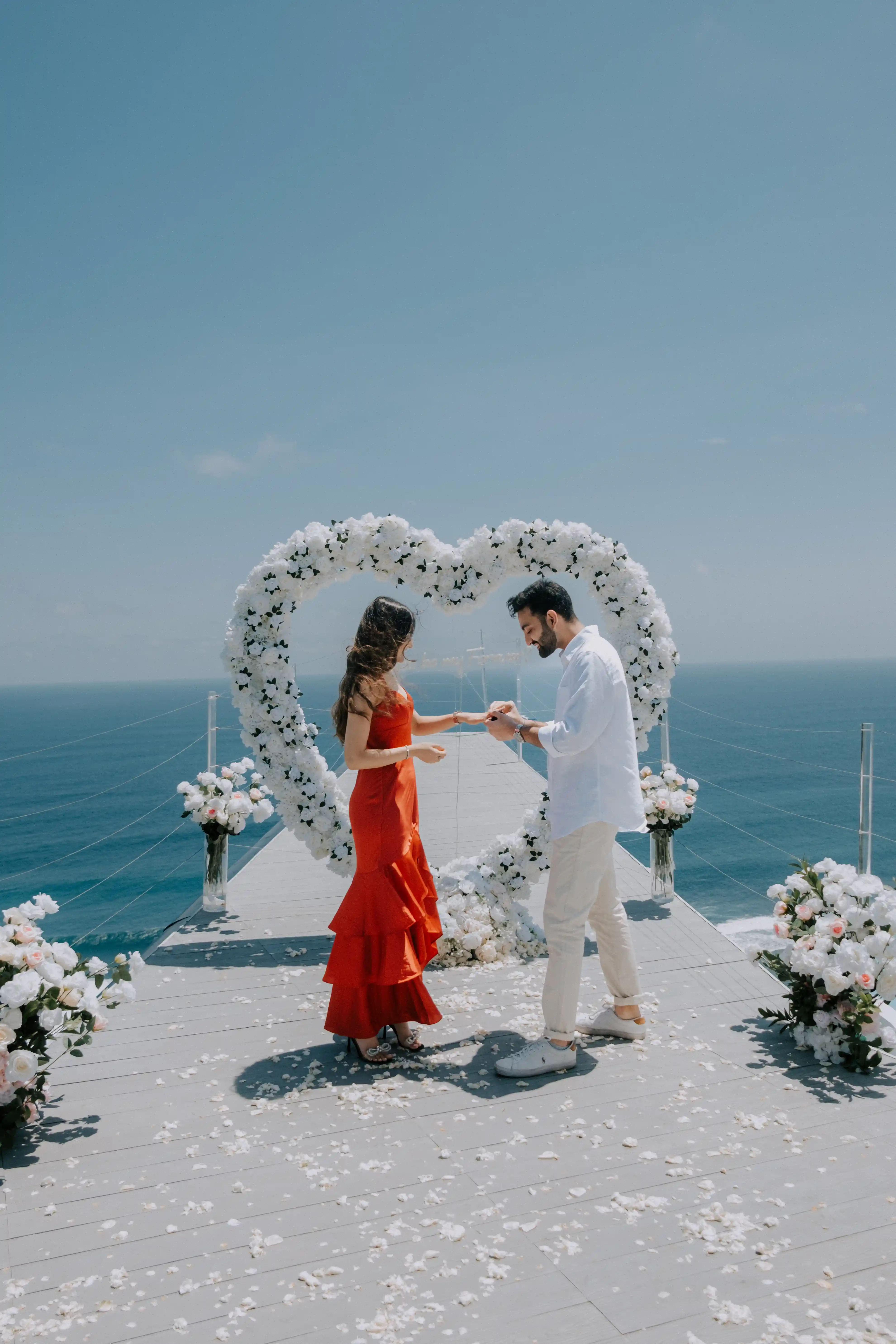Cliffside engagement moment in Bali with stunning ocean scenery.