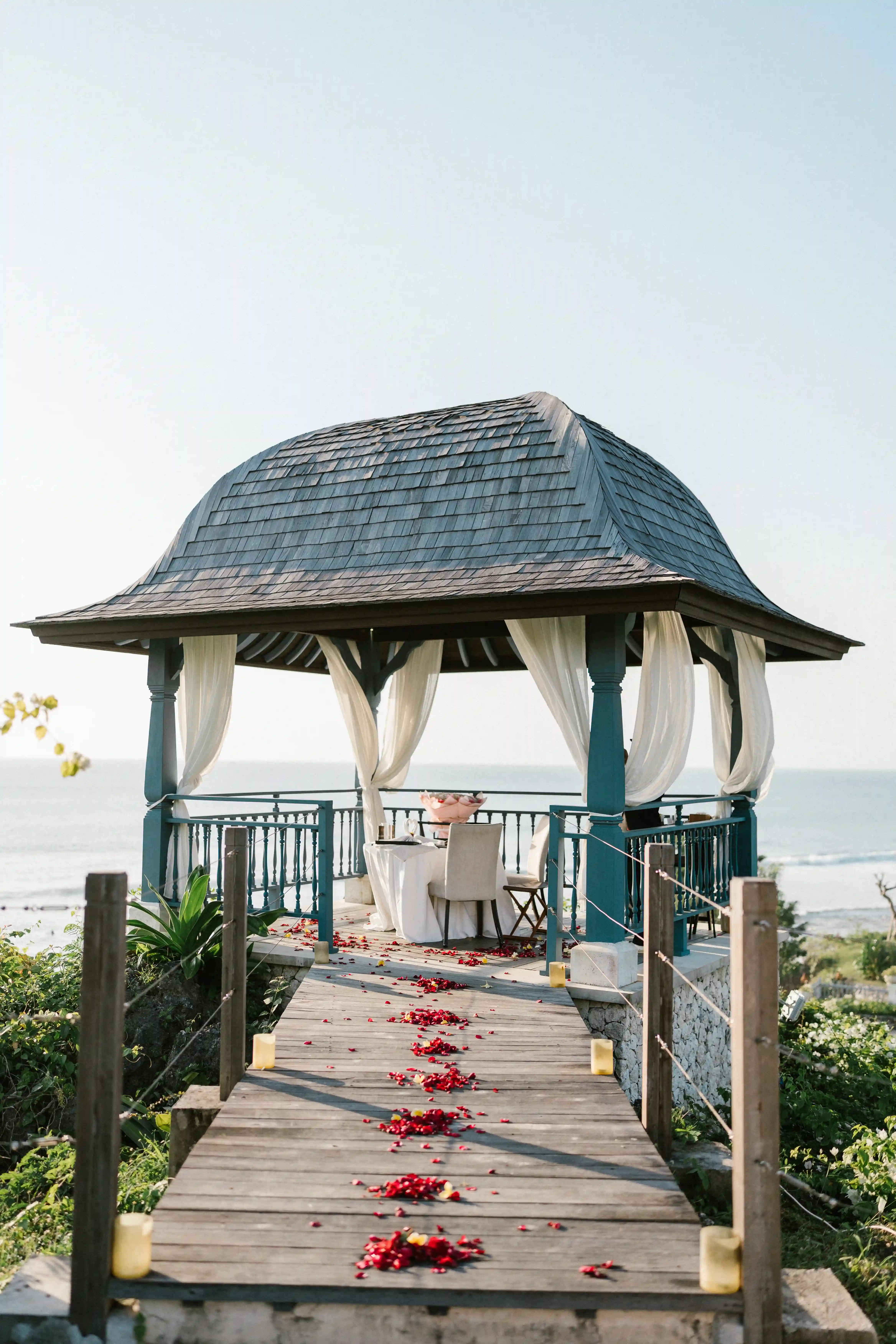 Sunset marriage proposal in Bali with pavilion and ocean view.