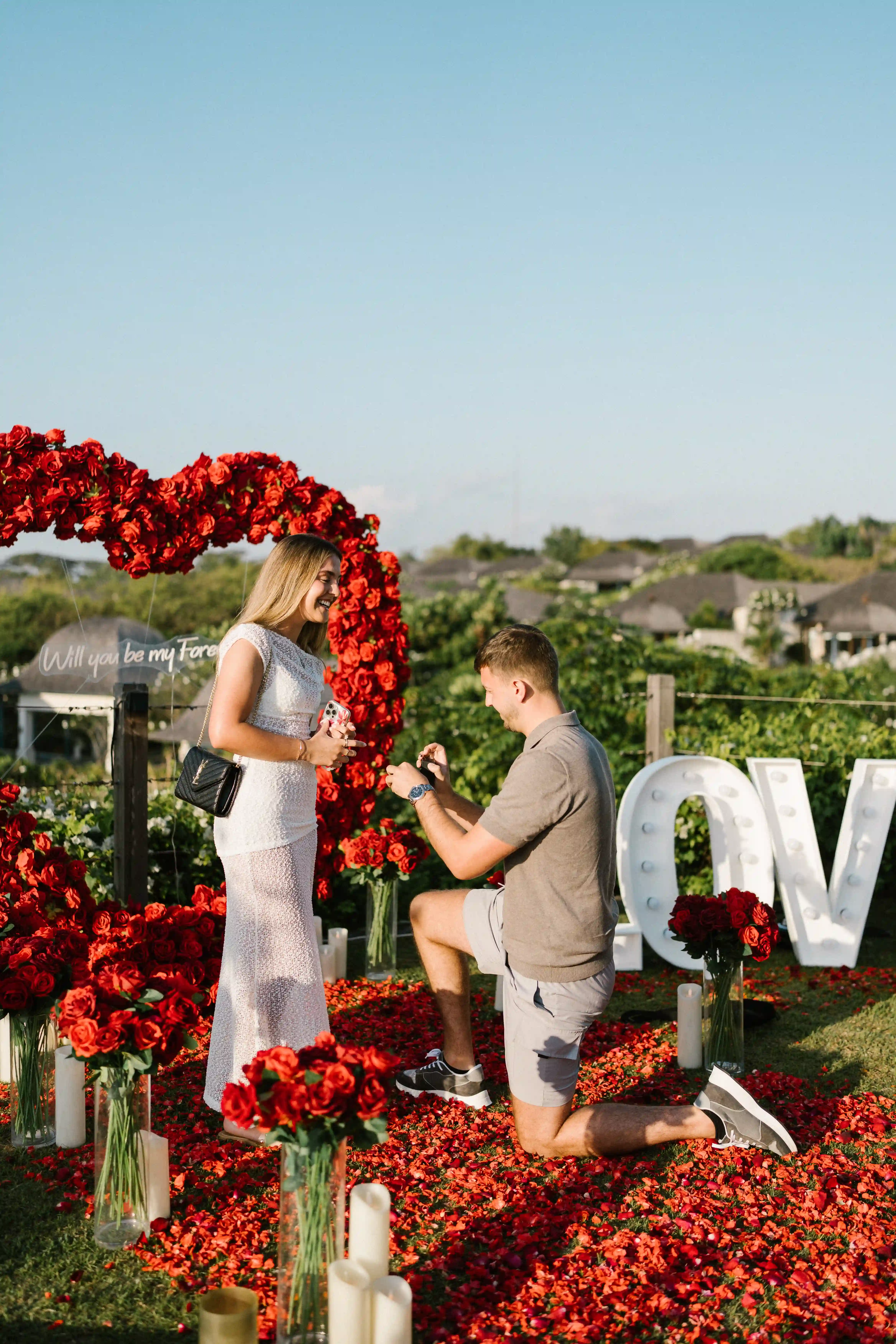 Romantic proposal decoration in Bali with red rose arch and LOVE sign.