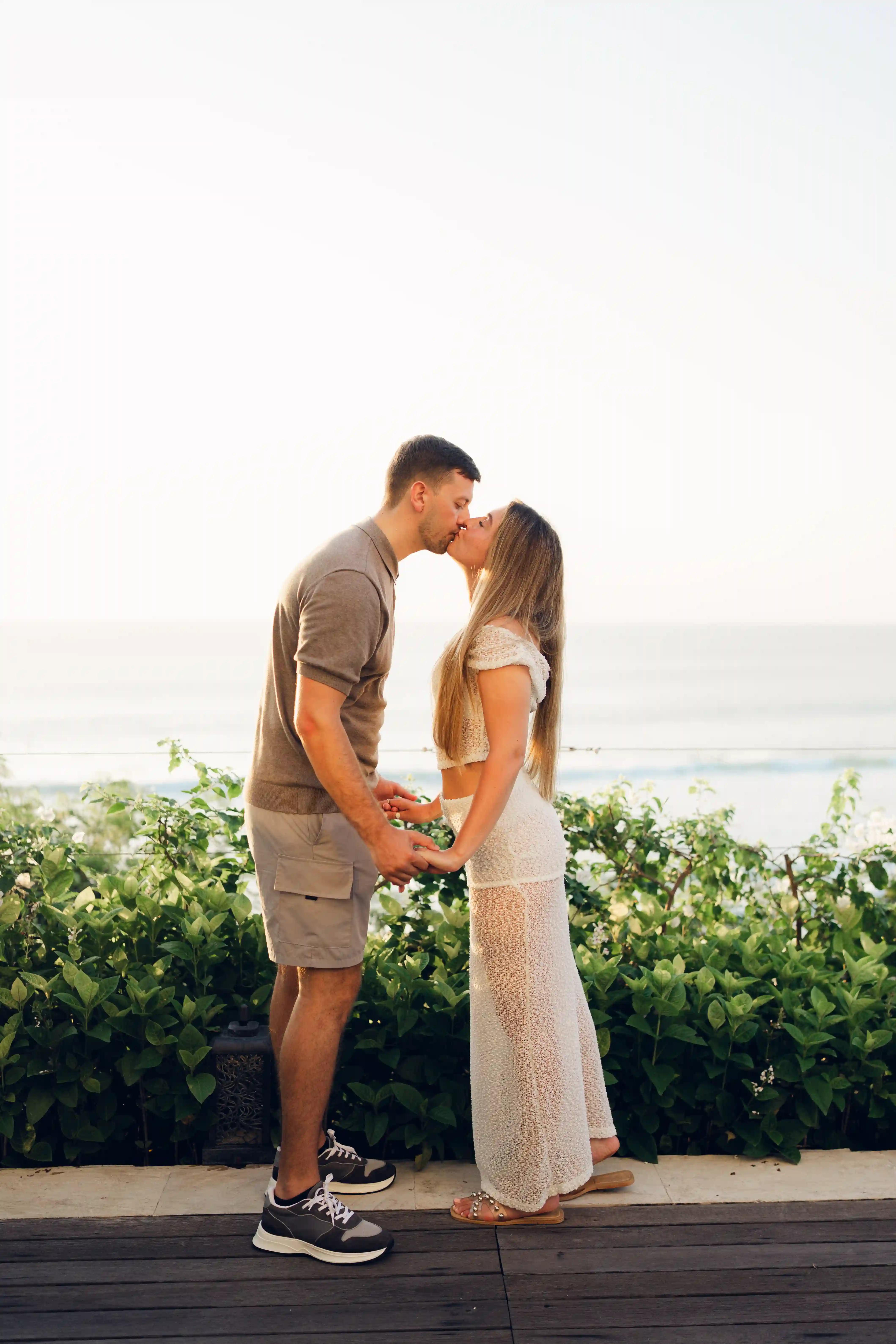 Couple kissing after Bali proposal on the cliff.