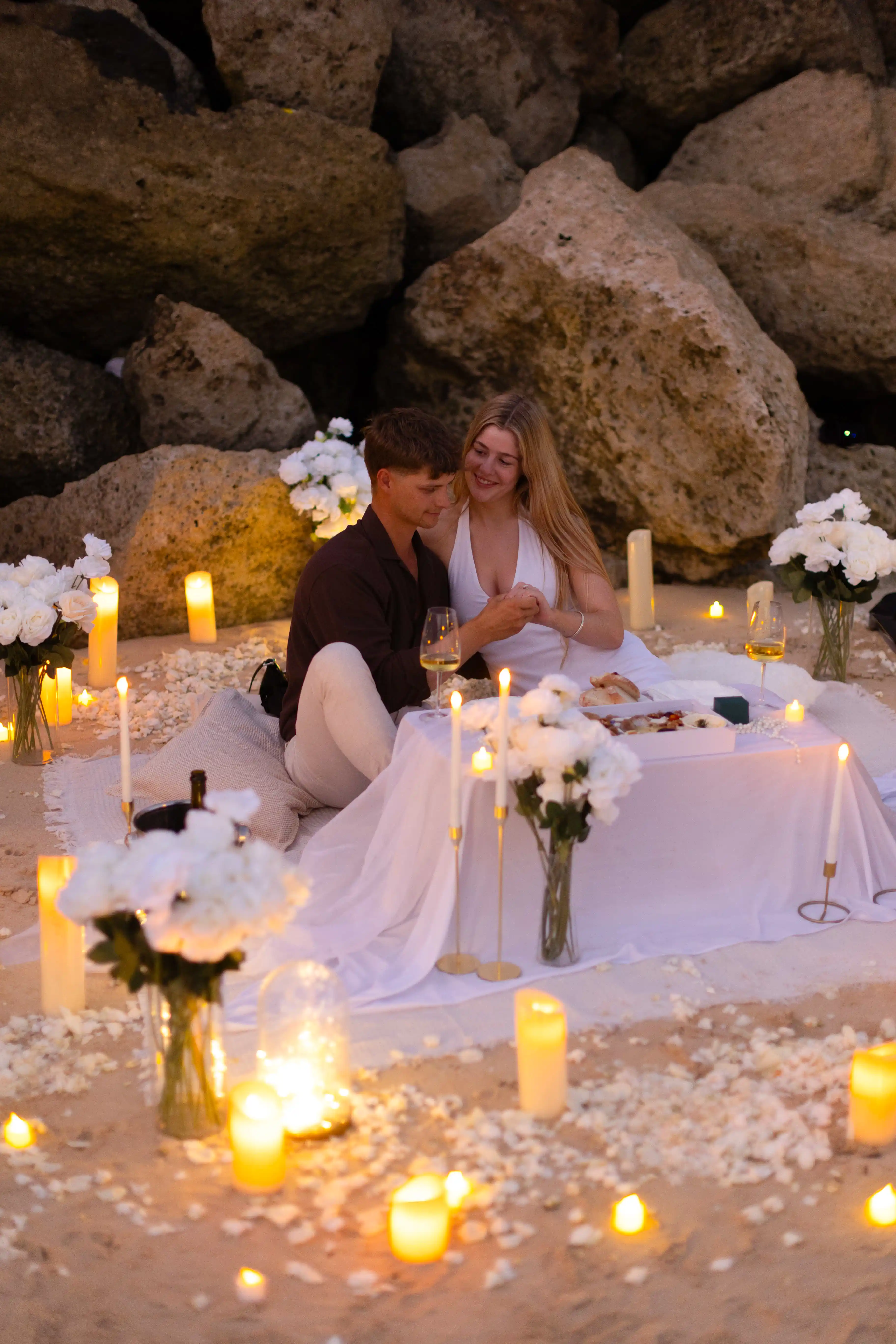 Dreamy Bali proposal setup with candles, flowers, and beach view.