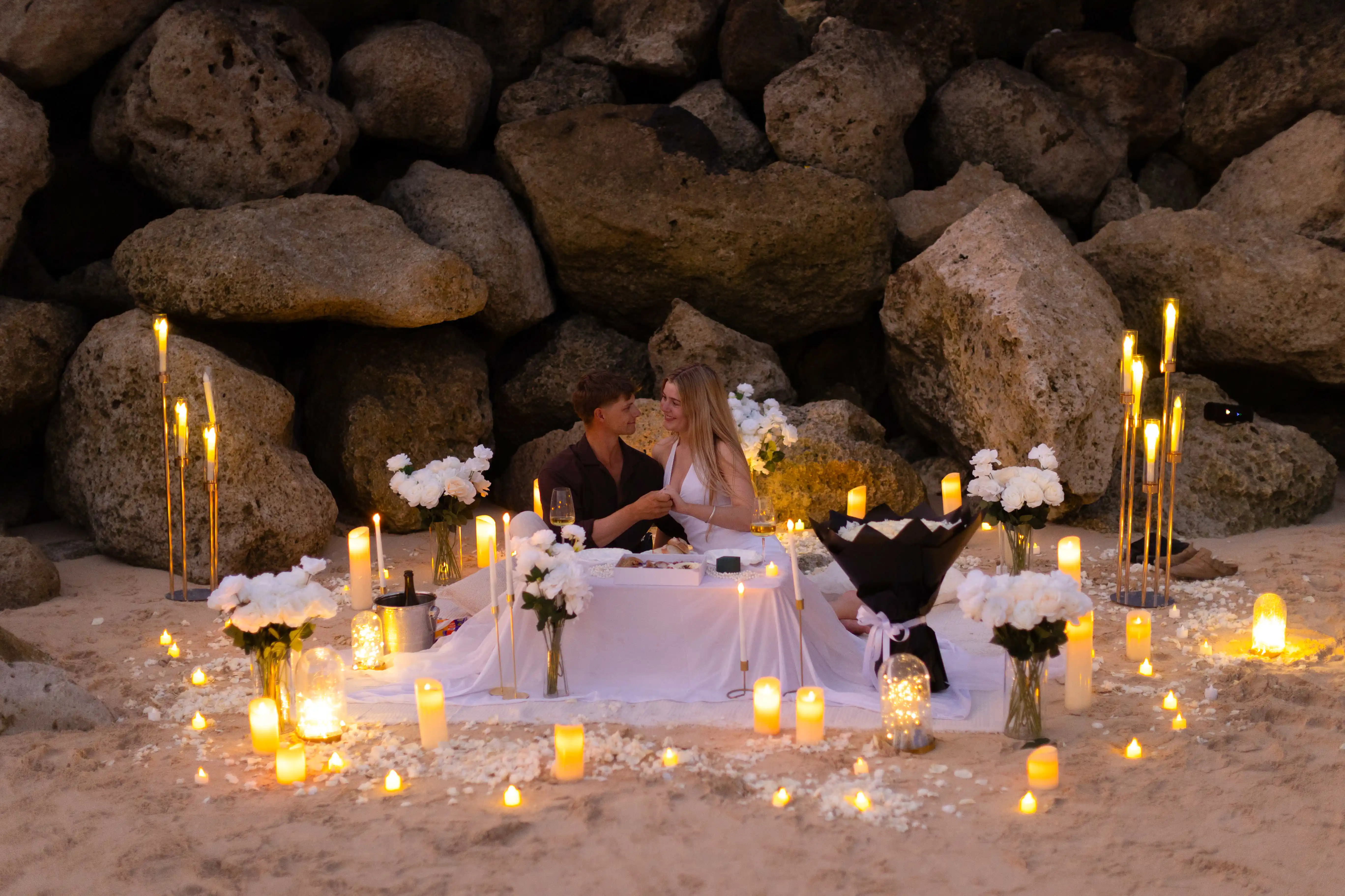 Surprise beach proposal in Bali with romantic candlelight picnic.