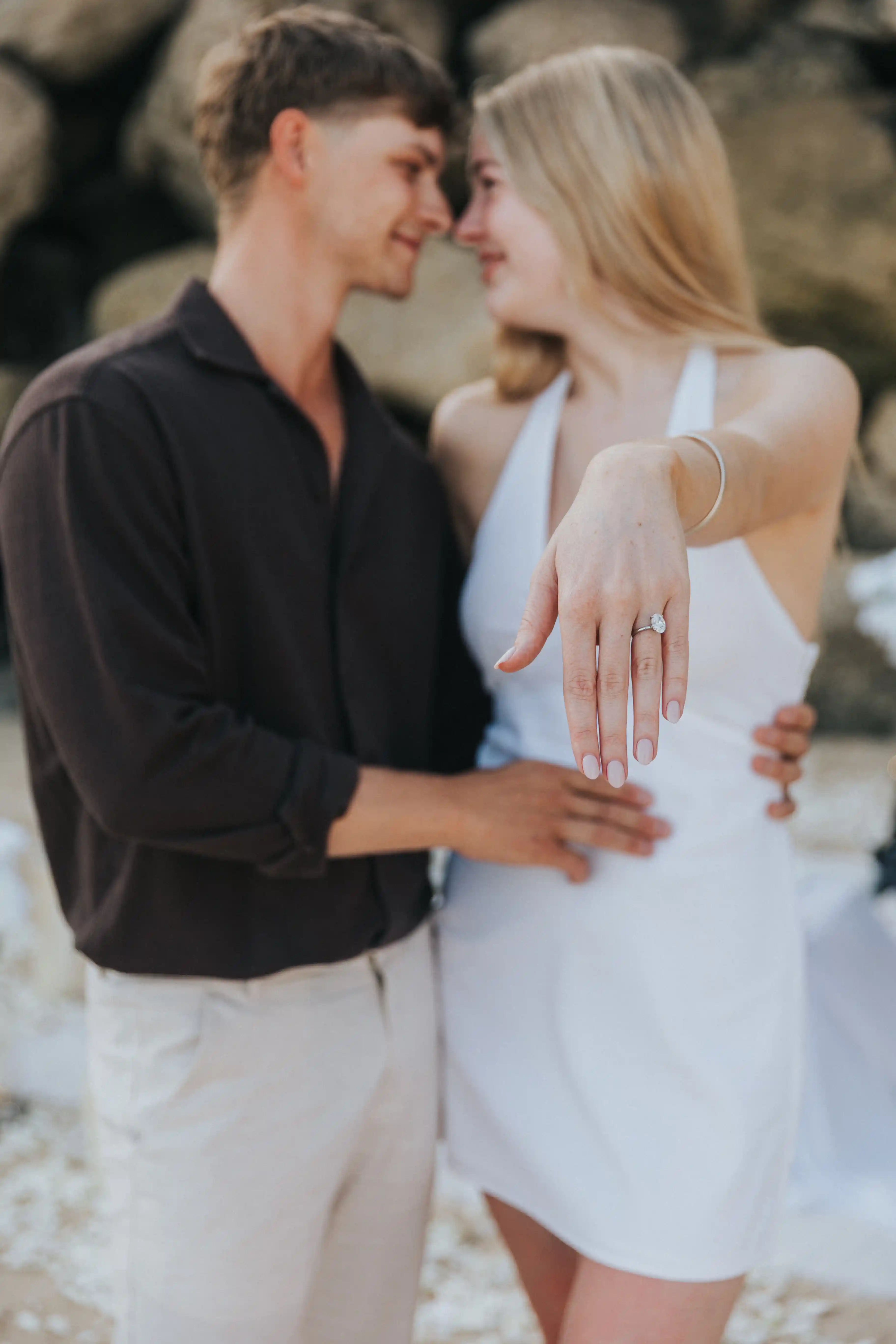 Couple showing engagement ring after a romantic beach proposal in Bali.