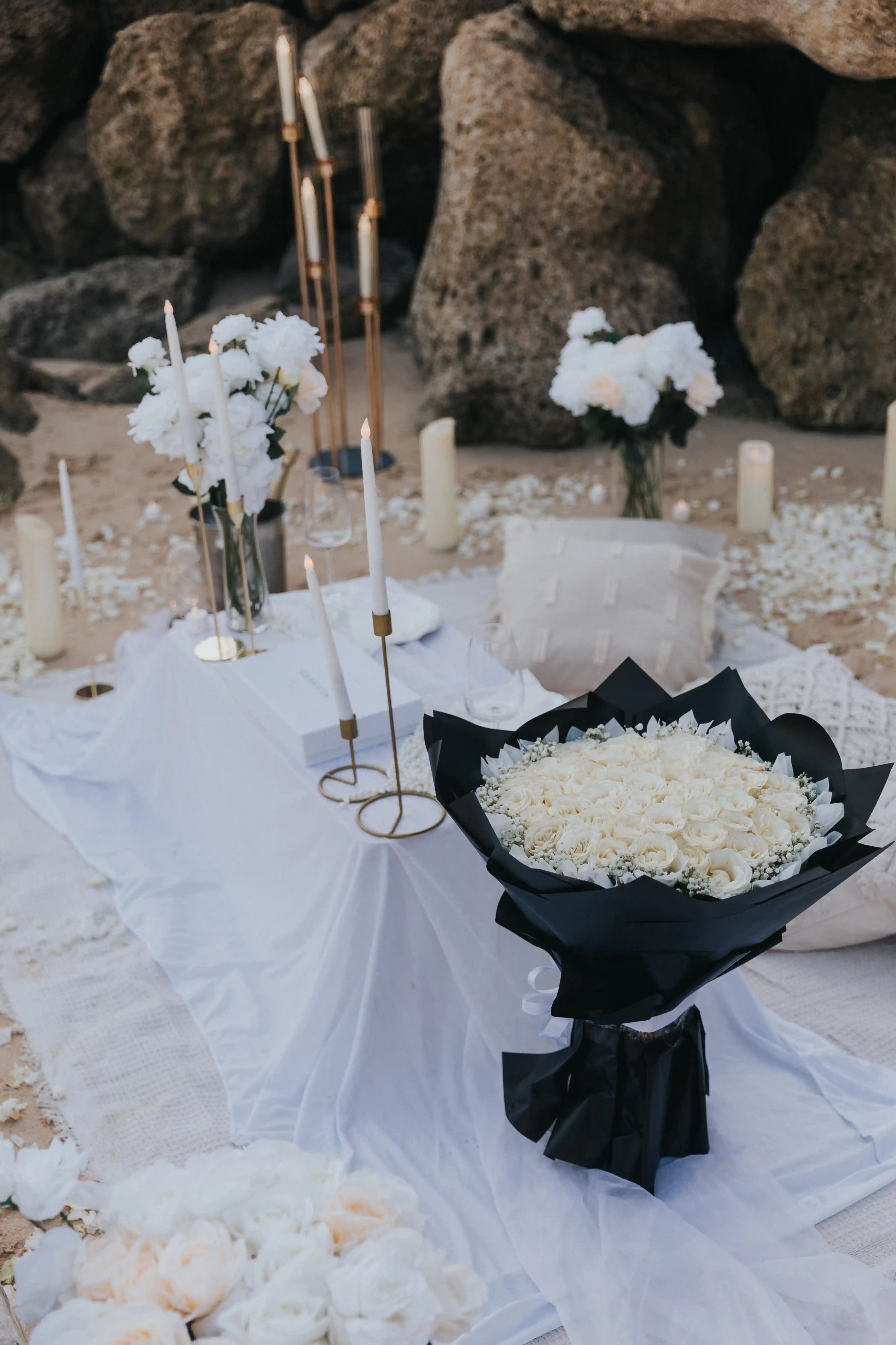 Elegant white picnic setup for a romantic beach proposal in Bali.