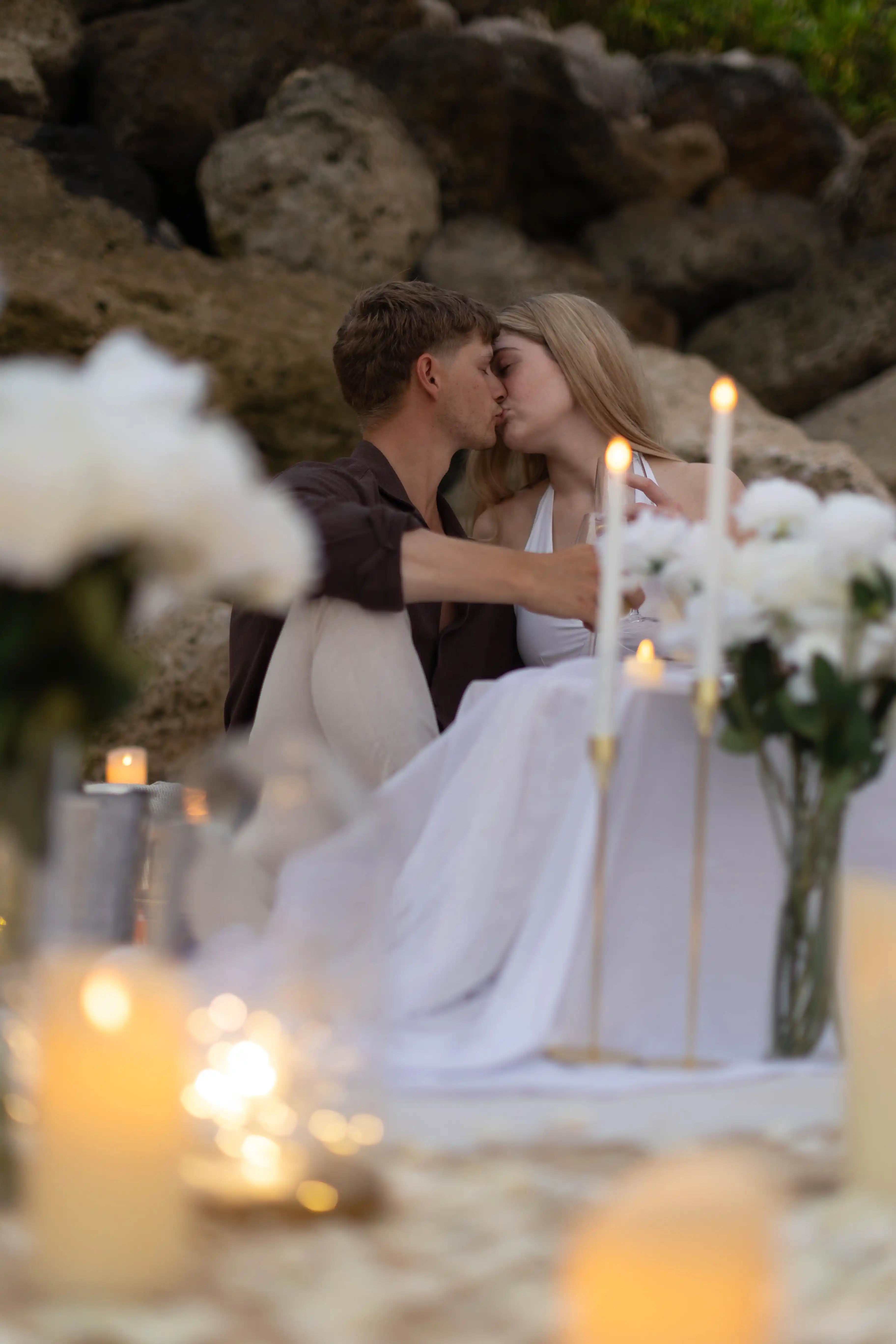 Engagement picnic on the beach in Bali with flowers and candles.