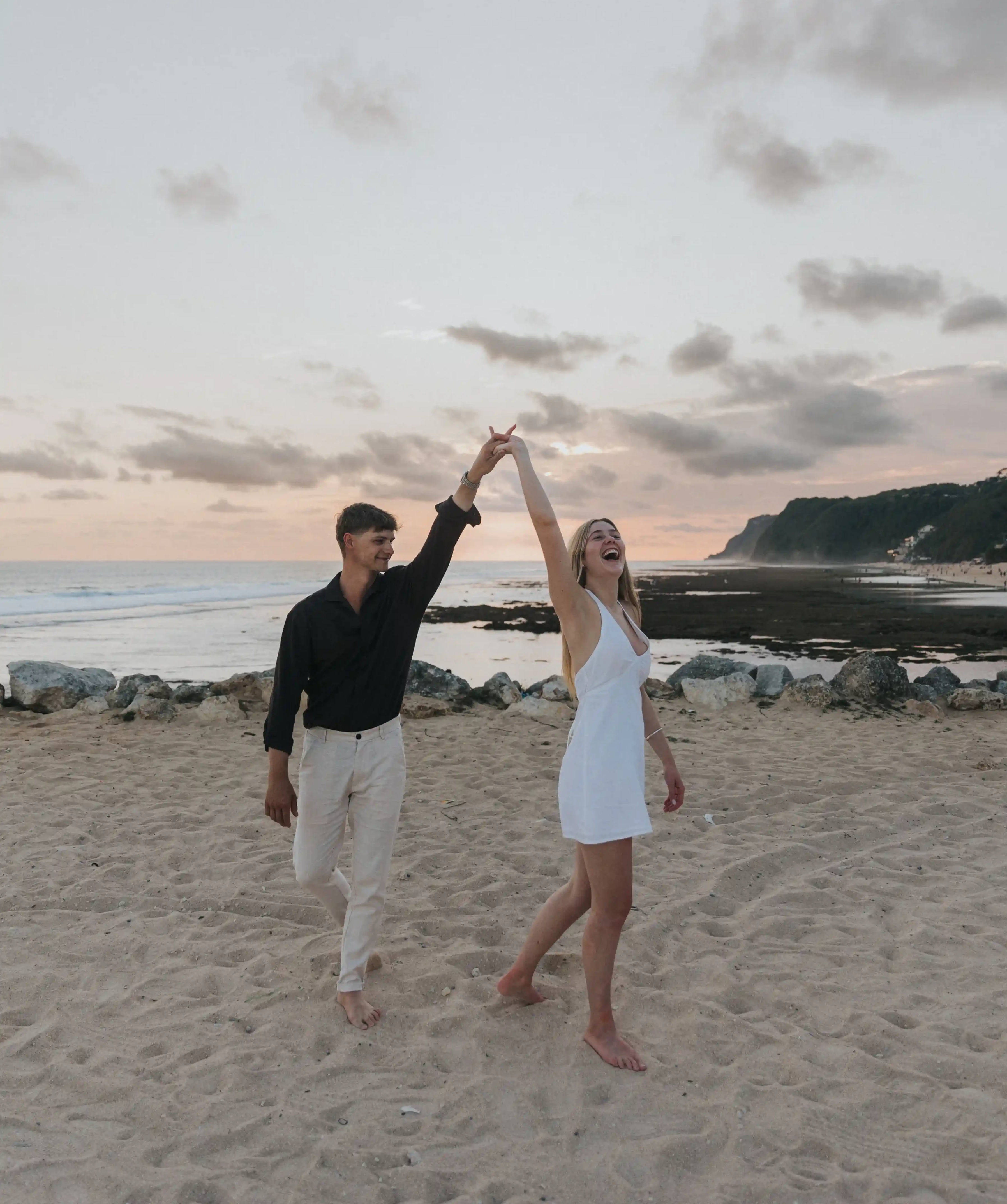 Romantic couple celebrating engagement by the ocean in Bali.