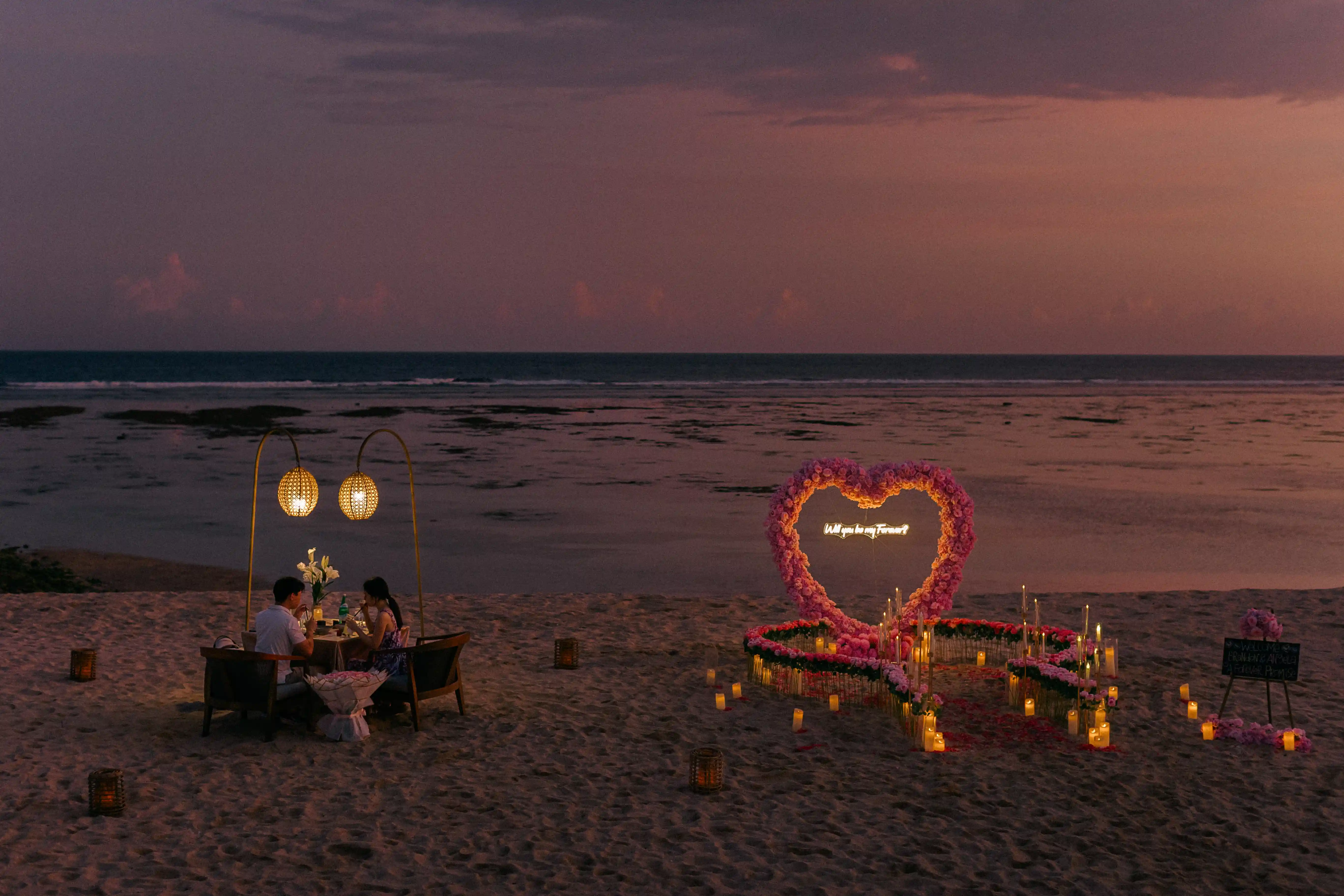 Surprise sunset proposal in Bali with candles and ocean view.