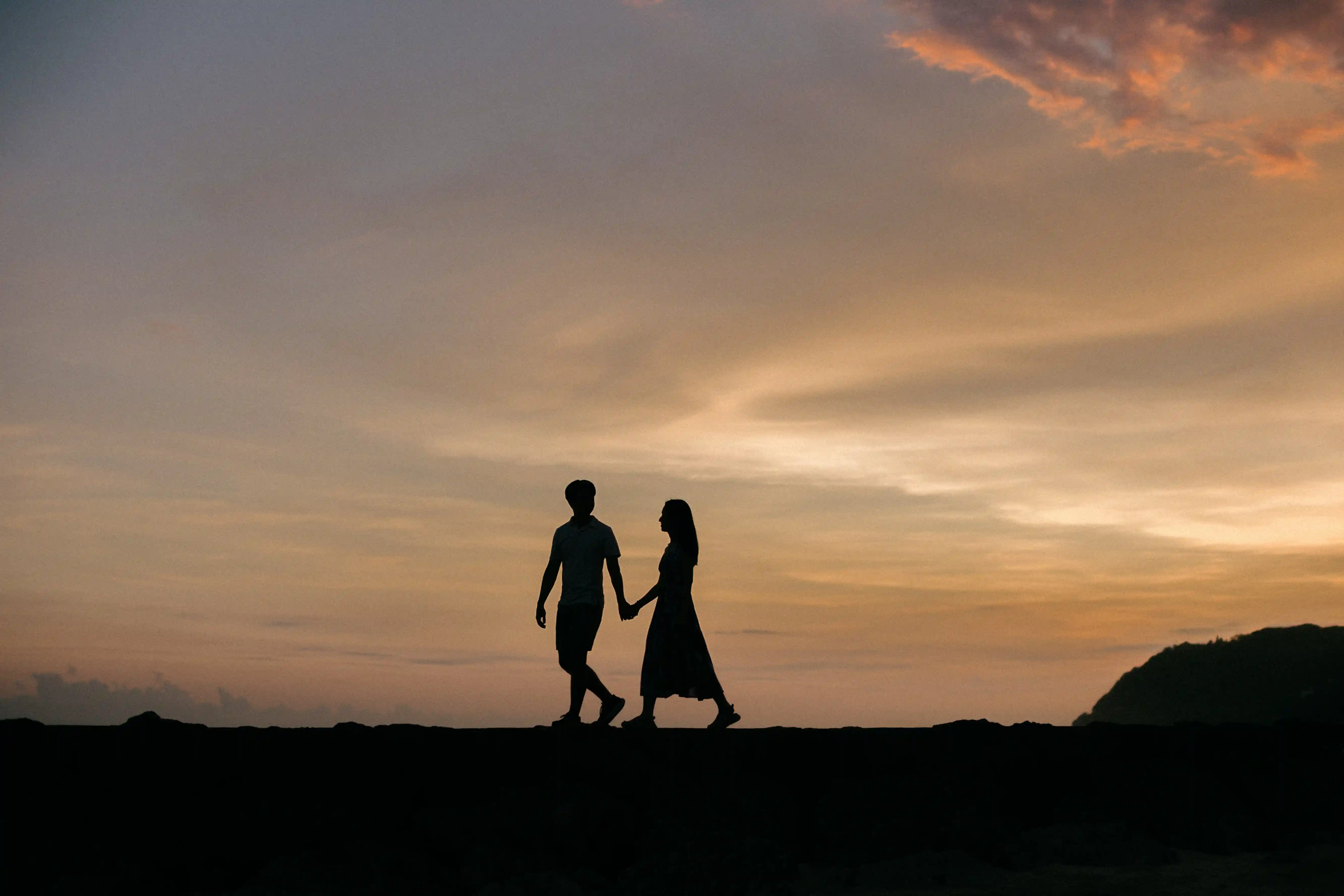Couple walking by the ocean after a Bali beach proposal.