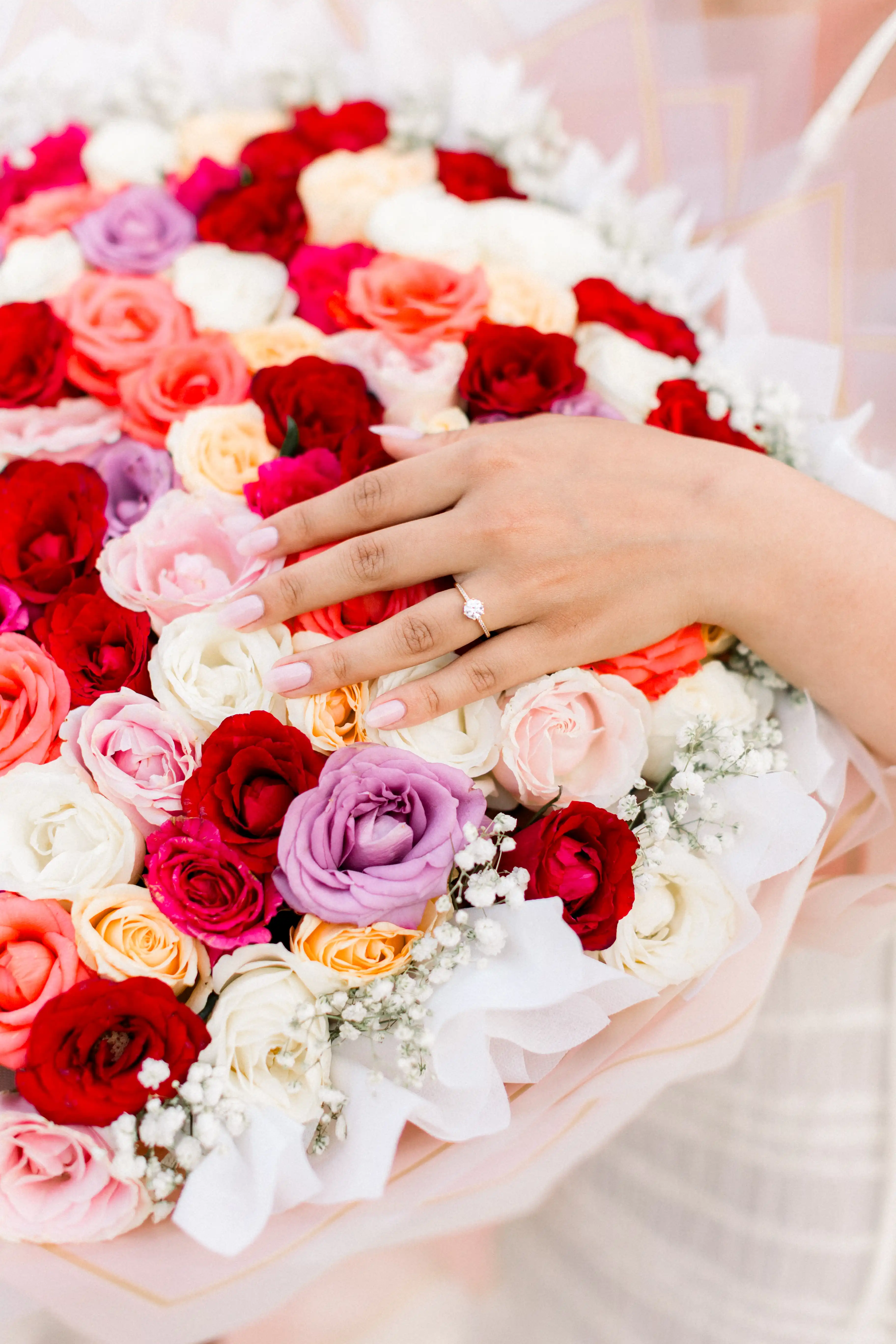 Close-up of engagement ring and rose petals after Bali proposal.