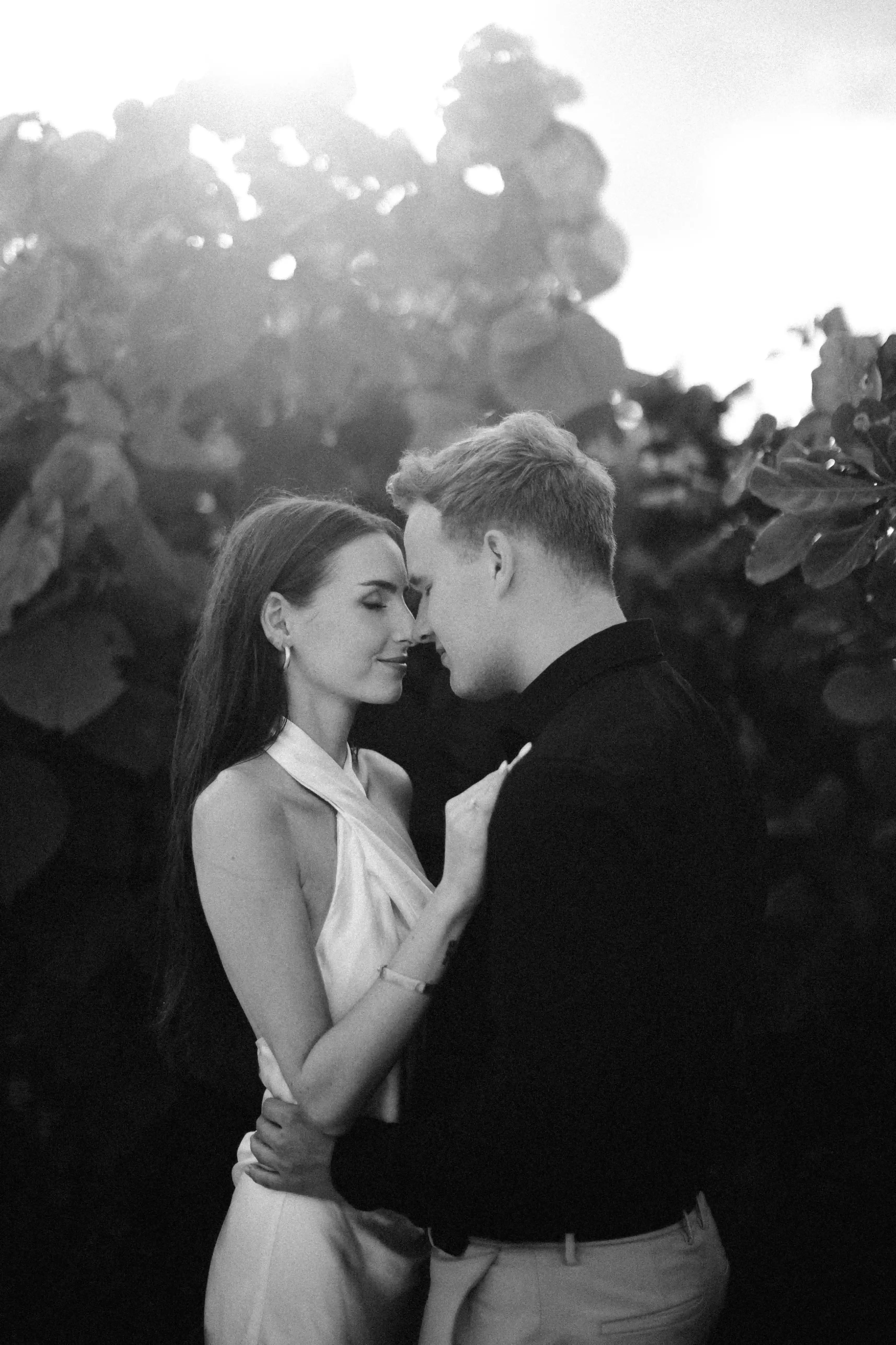 Black and white romantic portrait of Jasmin and Lucas in an intimate embrace.