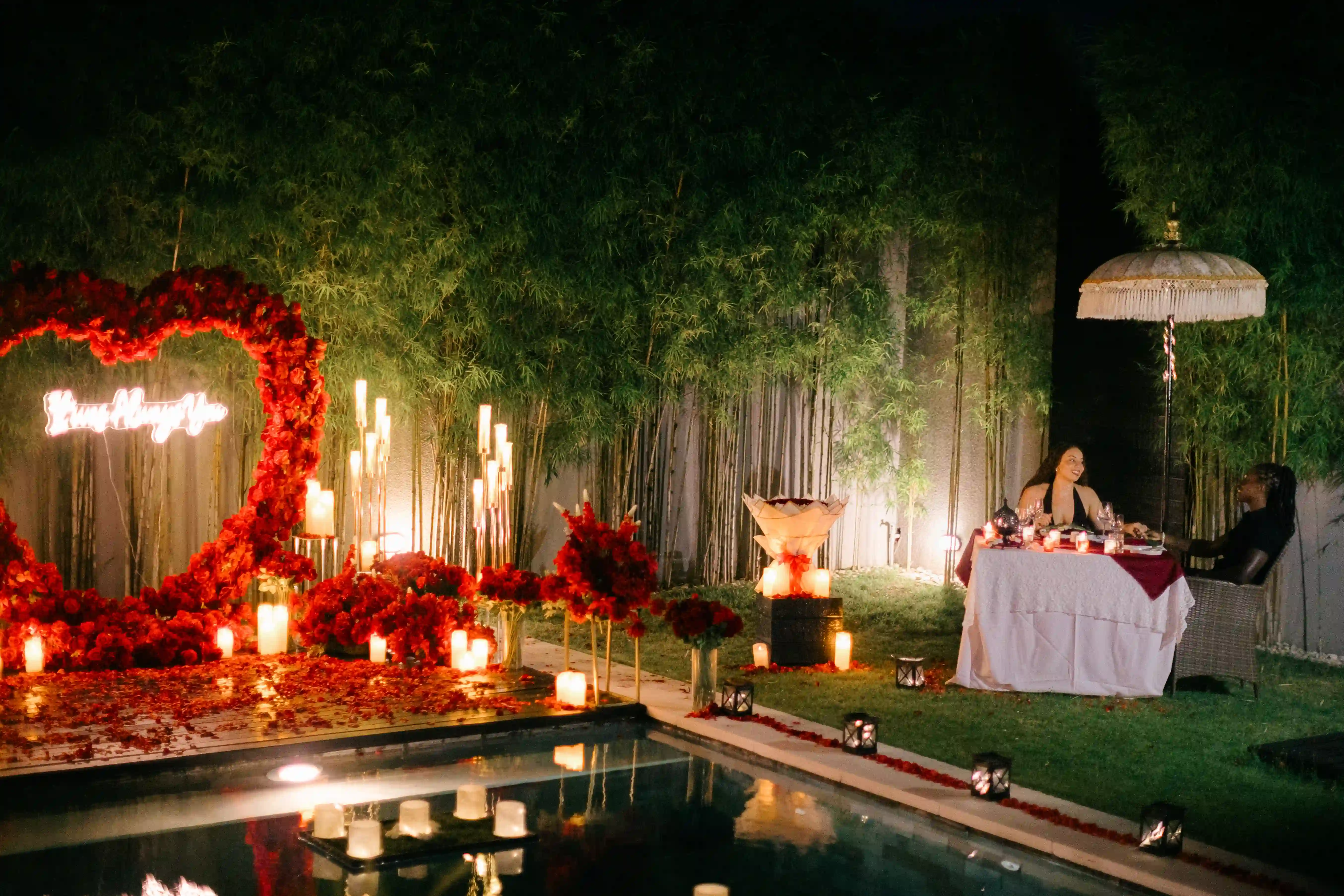 Romantic villa proposal setup in Bali with red roses, candles, and poolside decoration