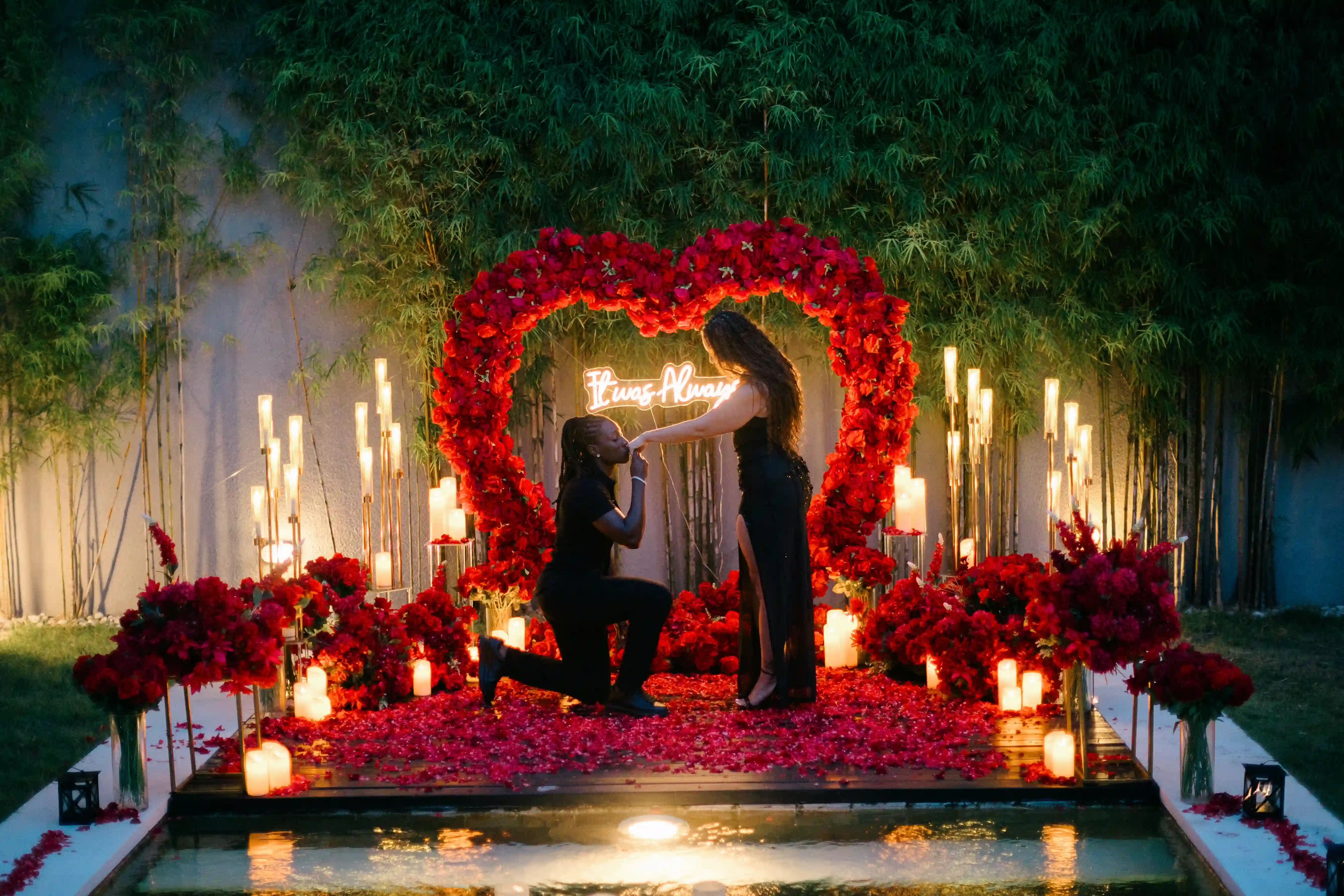 Couple walking toward romantic red rose proposal setup at private Bali villa