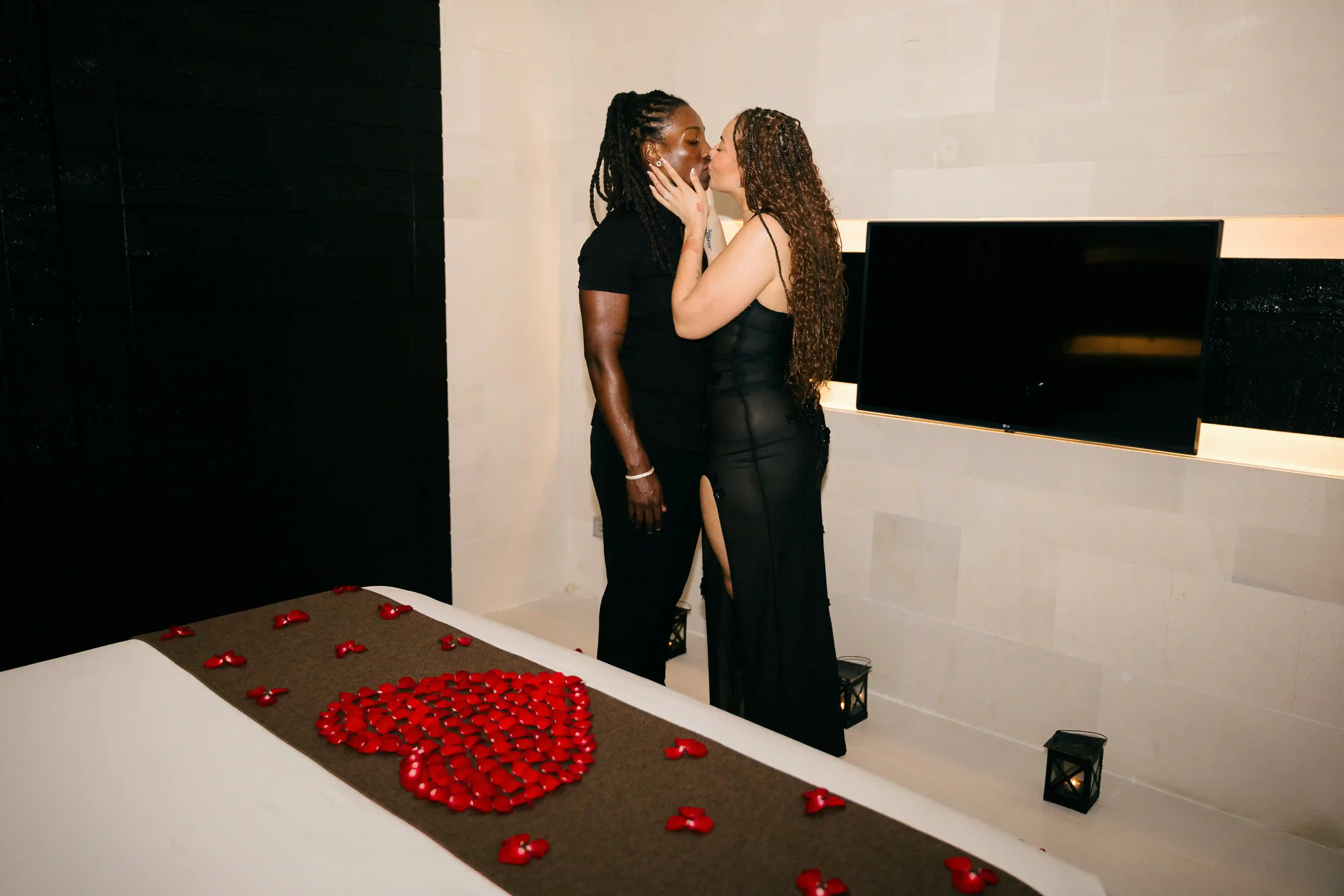 Couple entering villa room decorated with rose petals for romantic proposal night