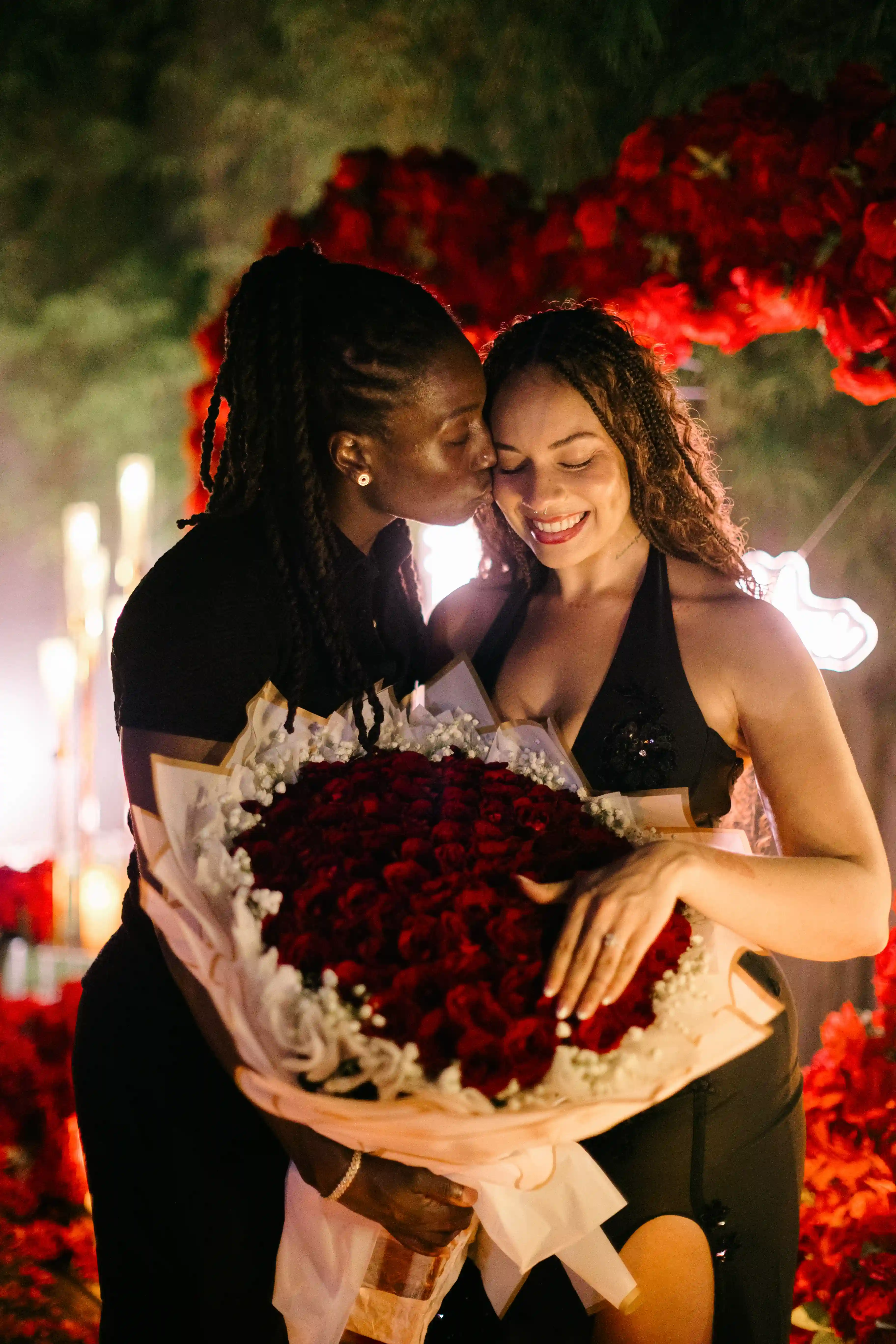 Couple celebrating their engagement with rose bouquet at romantic villa proposal in Bali