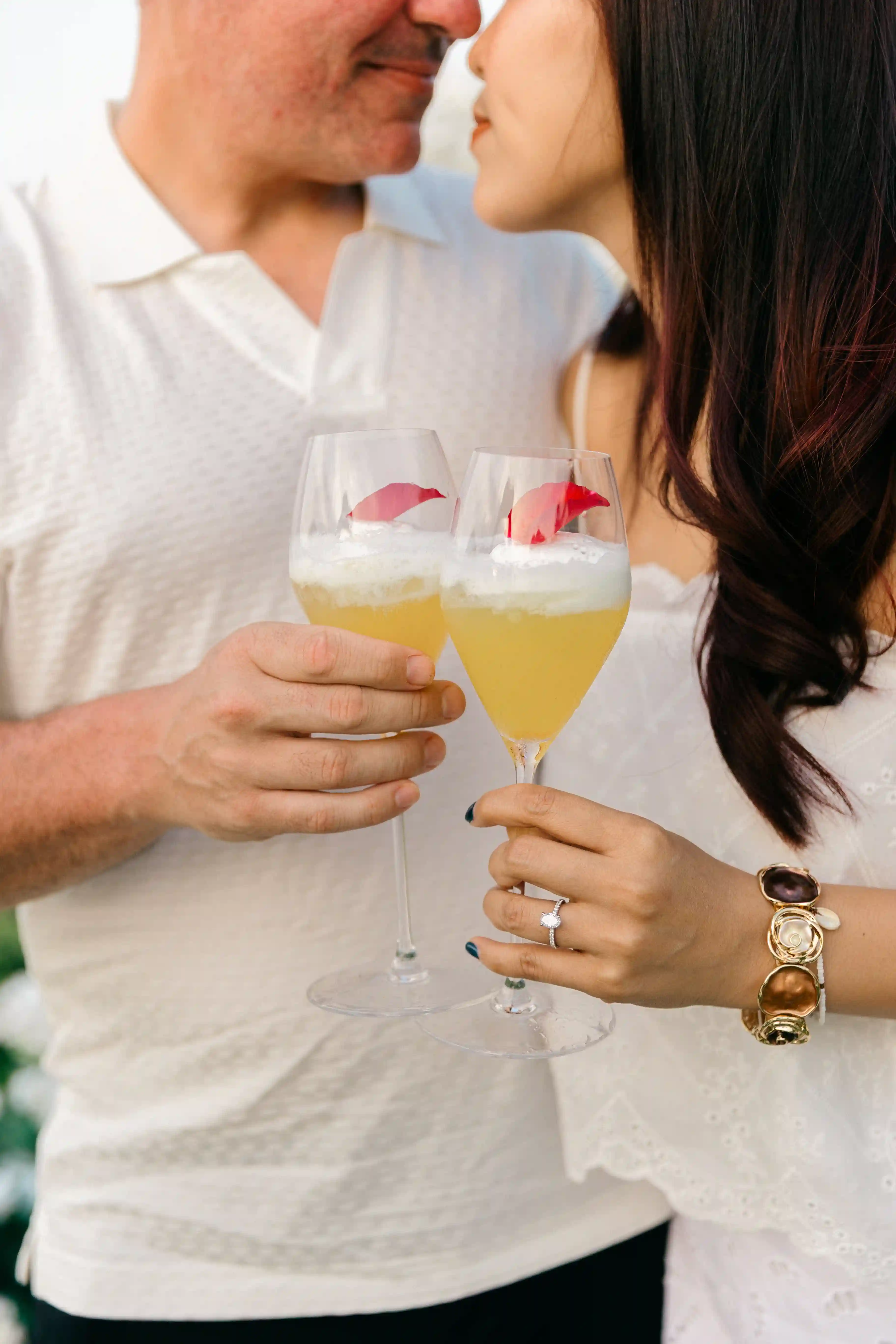 Couple holding drinks during romantic engagement dinner in Bali