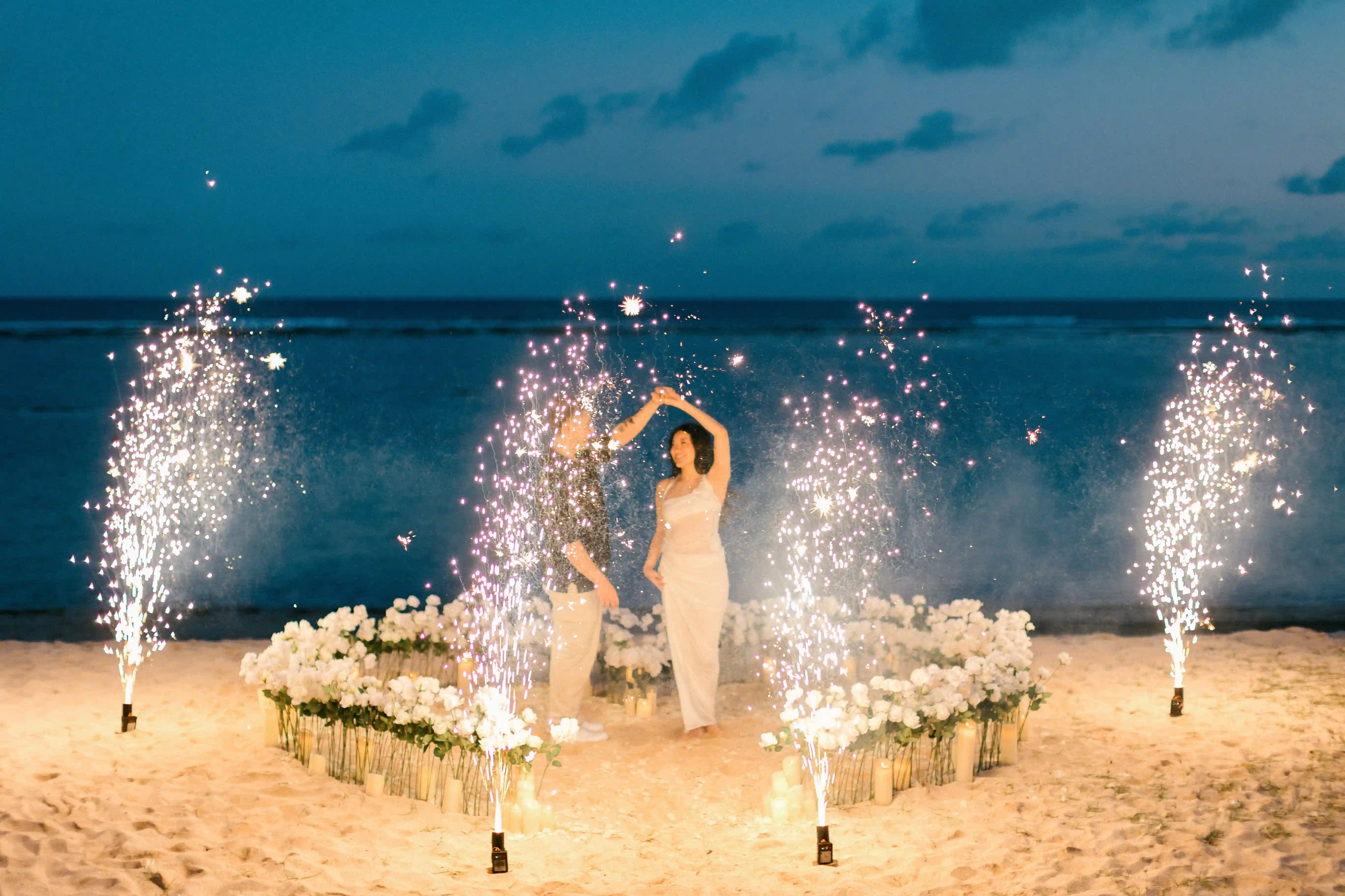 Luxury beach proposal celebration with pyrotechnics in Bali at night