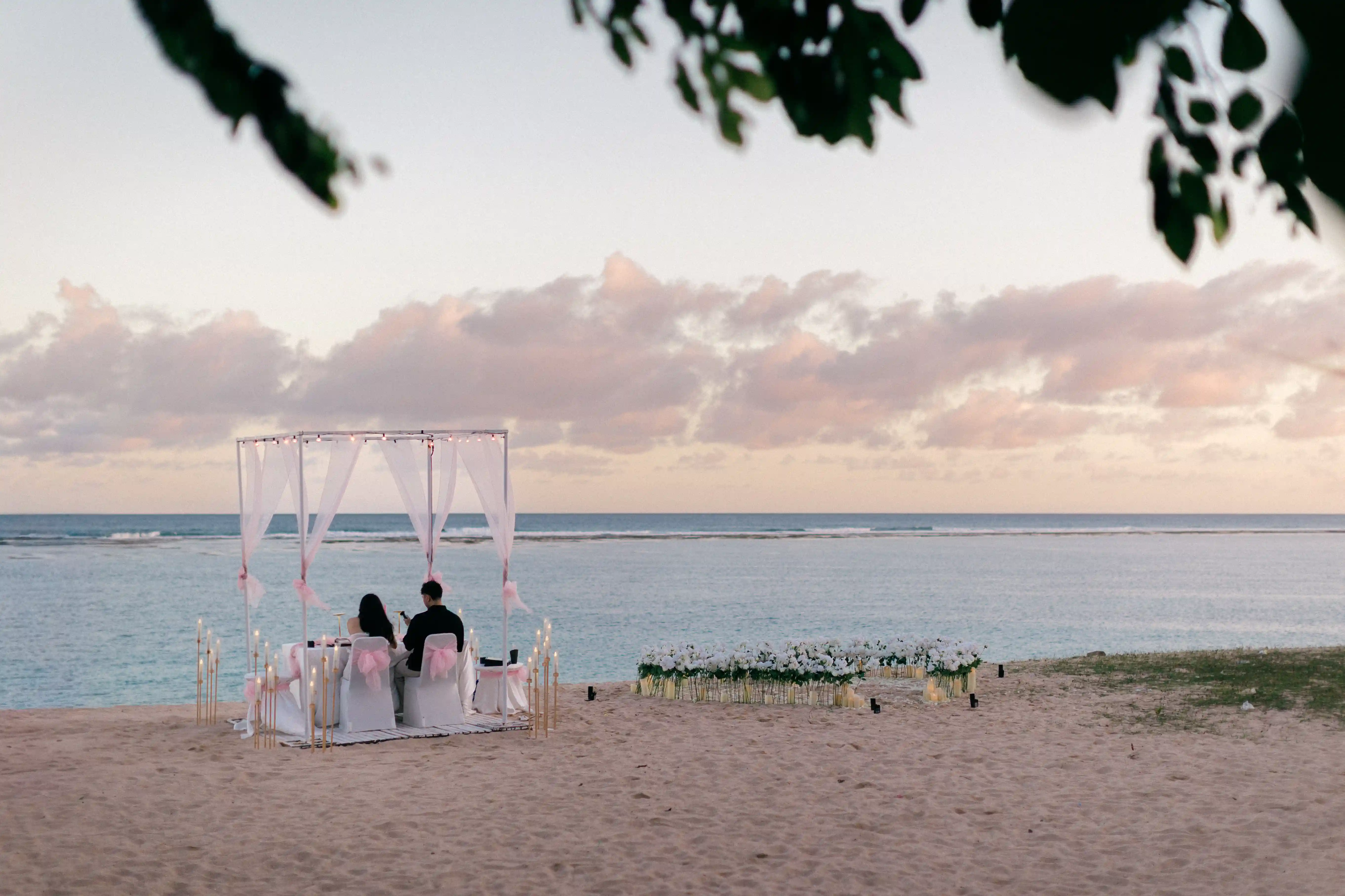 Wide-angle view of private beach proposal setup overlooking the ocean