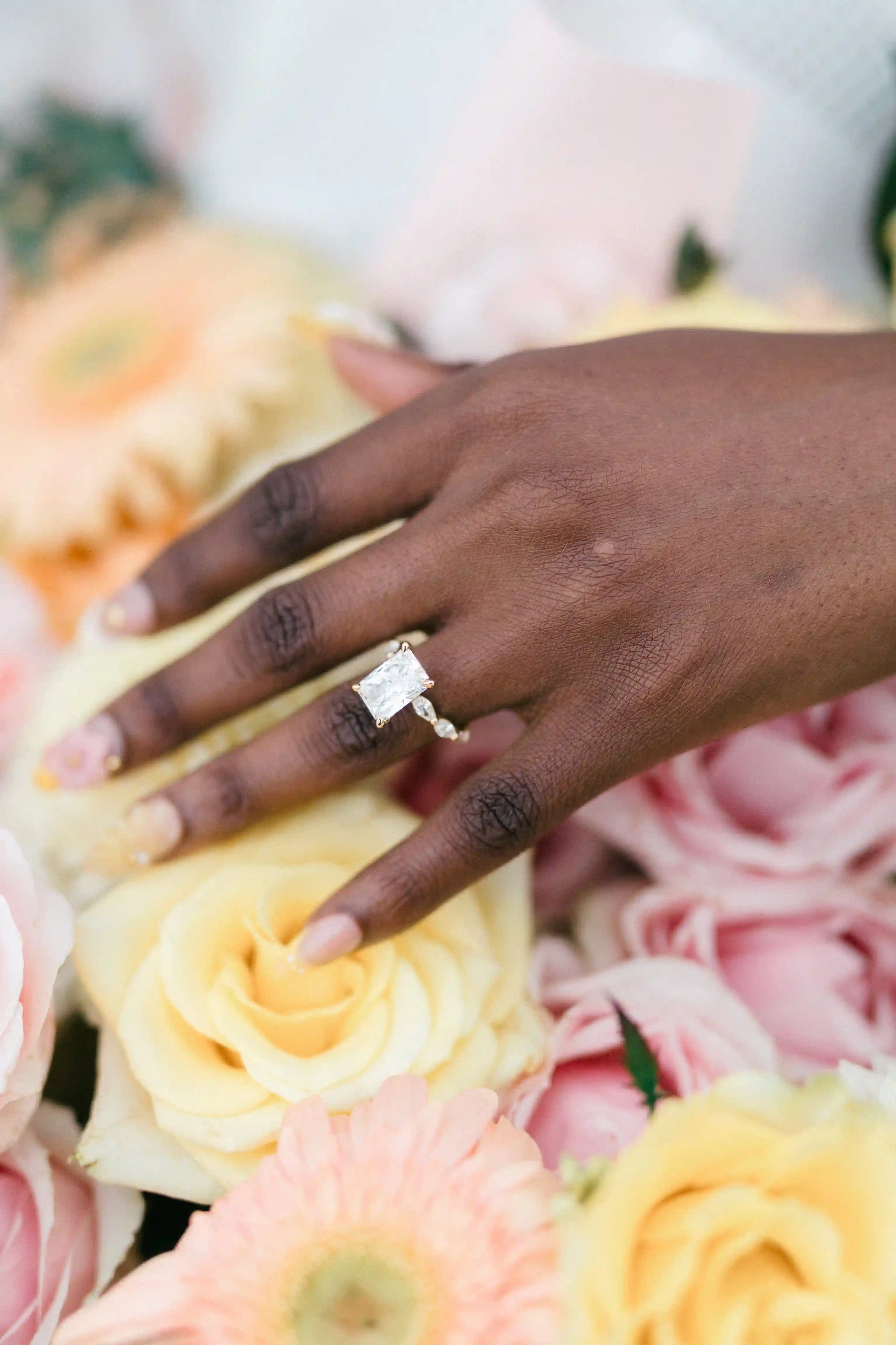 Close-up of engagement ring above luxury rose arrangement