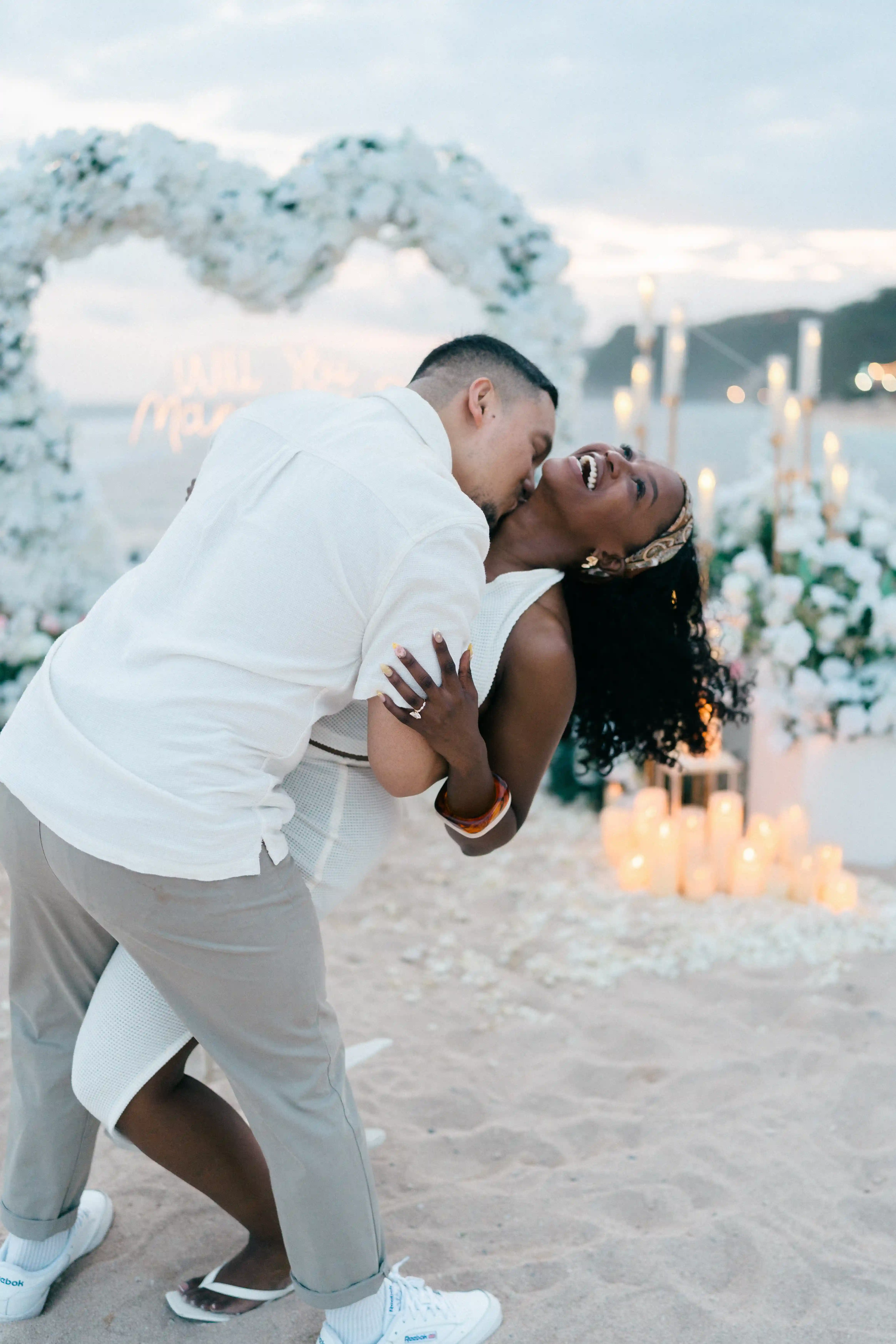 Romantic dip kiss during sunset beach proposal in Bali