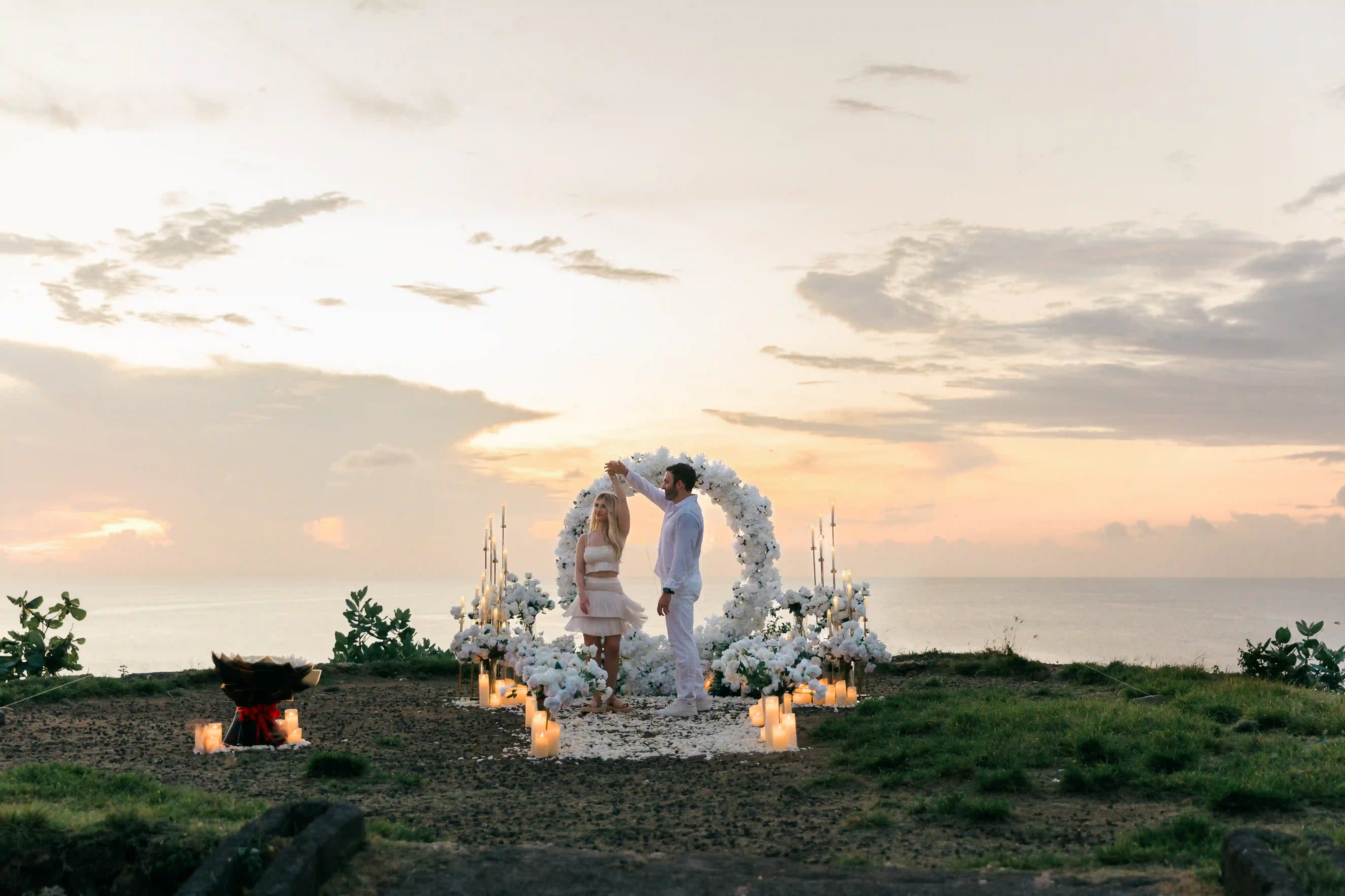 Wide-angle view of luxury Bali proposal setup at sunset
