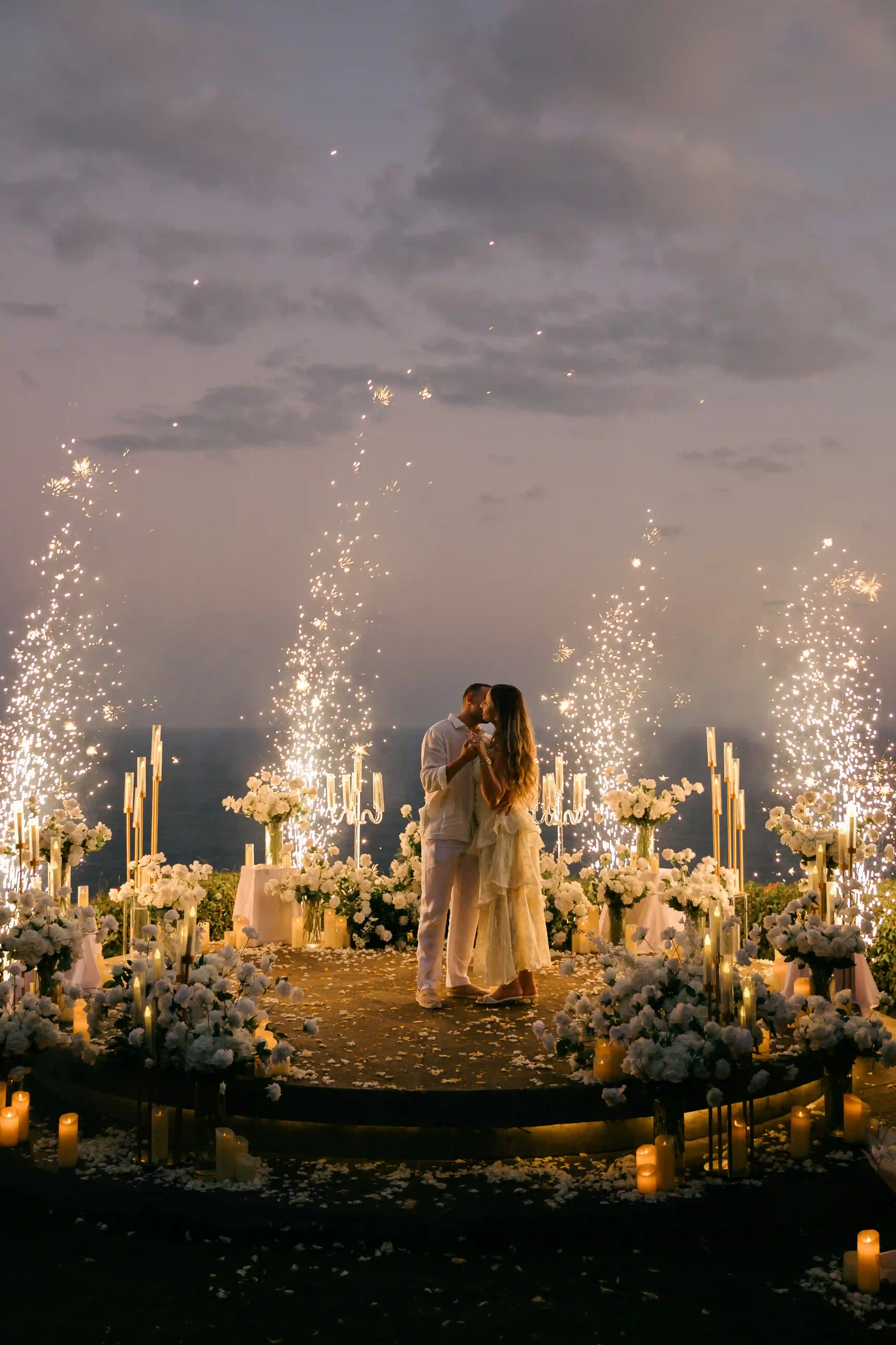 Sparklers lighting a clifftop proposal setup in Bali at sunset