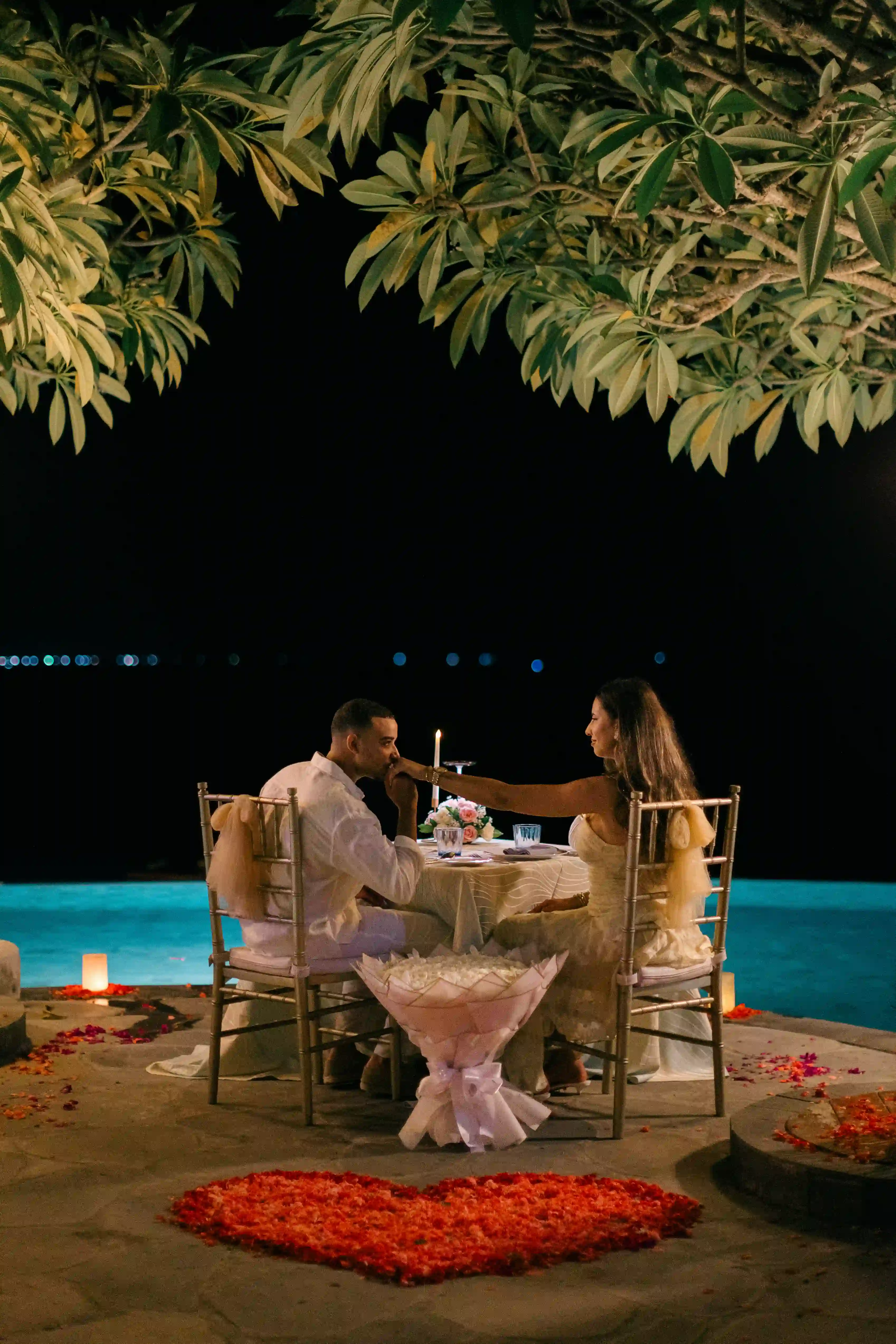 Candlelit proposal dinner with hanging lanterns in Bali at night
