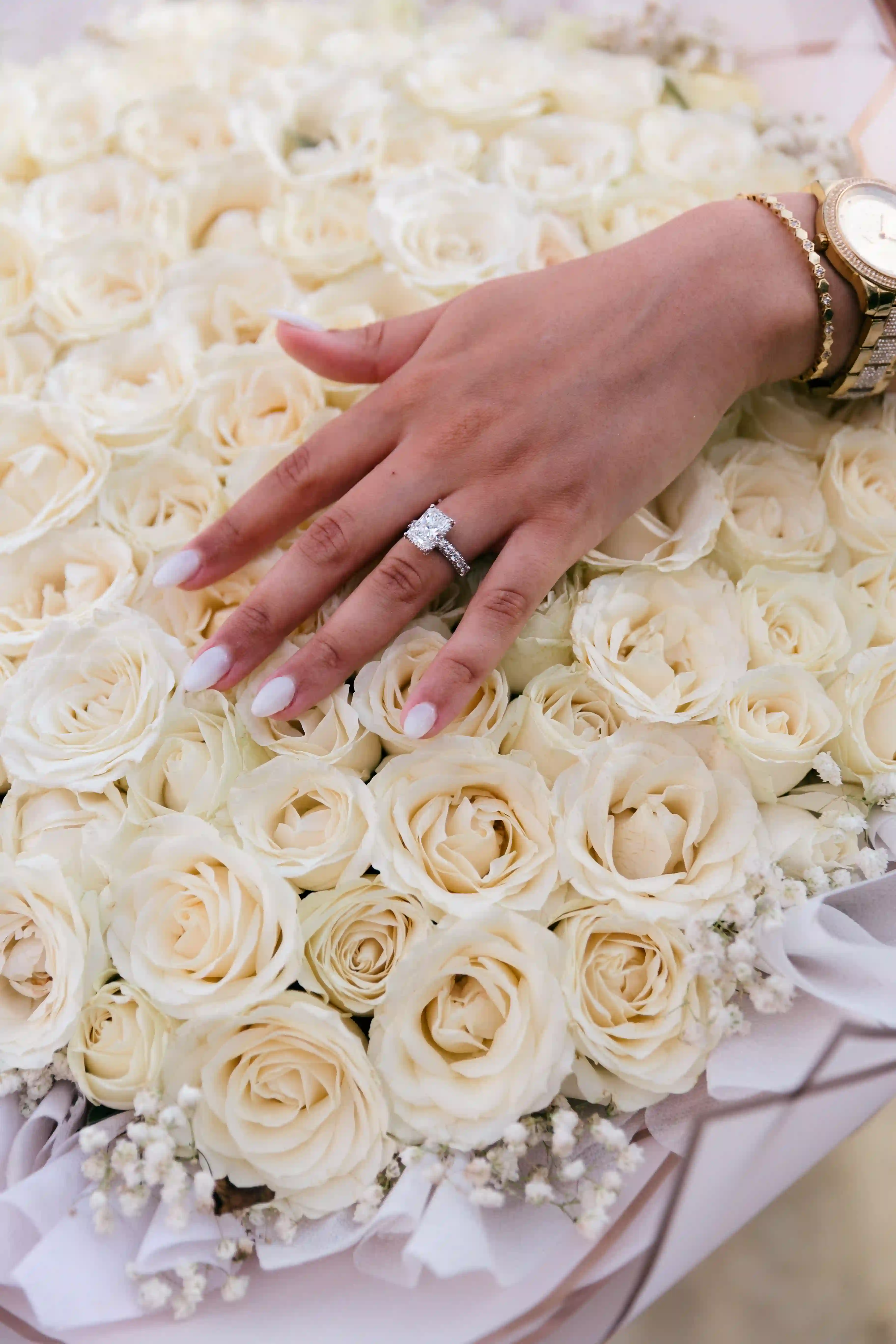 Engagement ring on a white rose bouquet at a Bali proposal