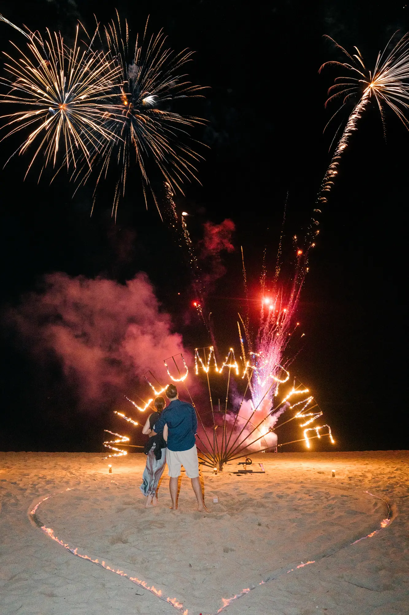 Fireworks and coloured smoke over a beach proposal setup in Bali