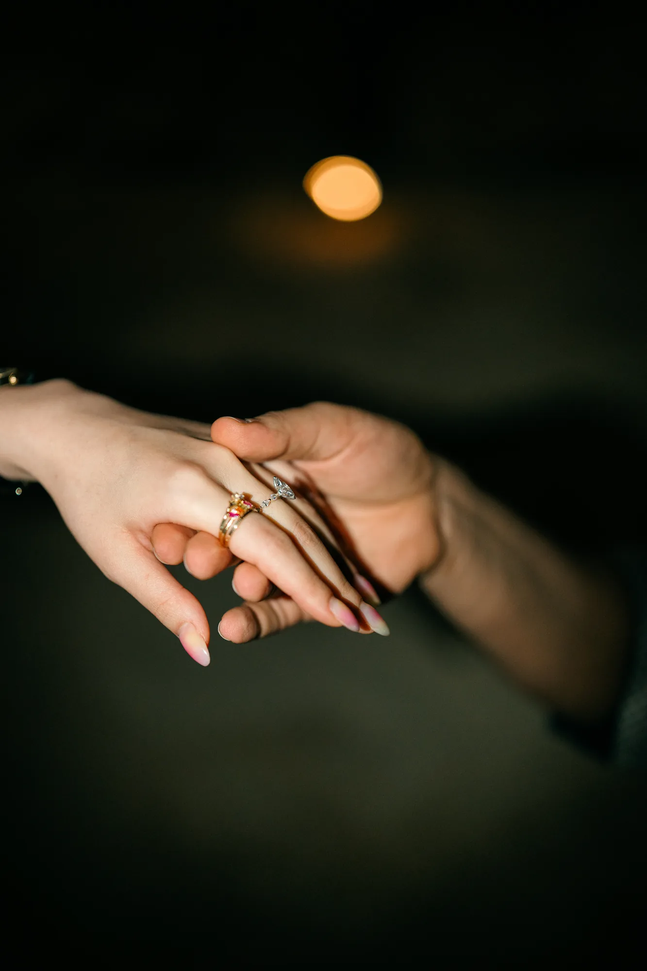 Close-up of the engagement ring on her hand under the moon at a Bali beach proposal