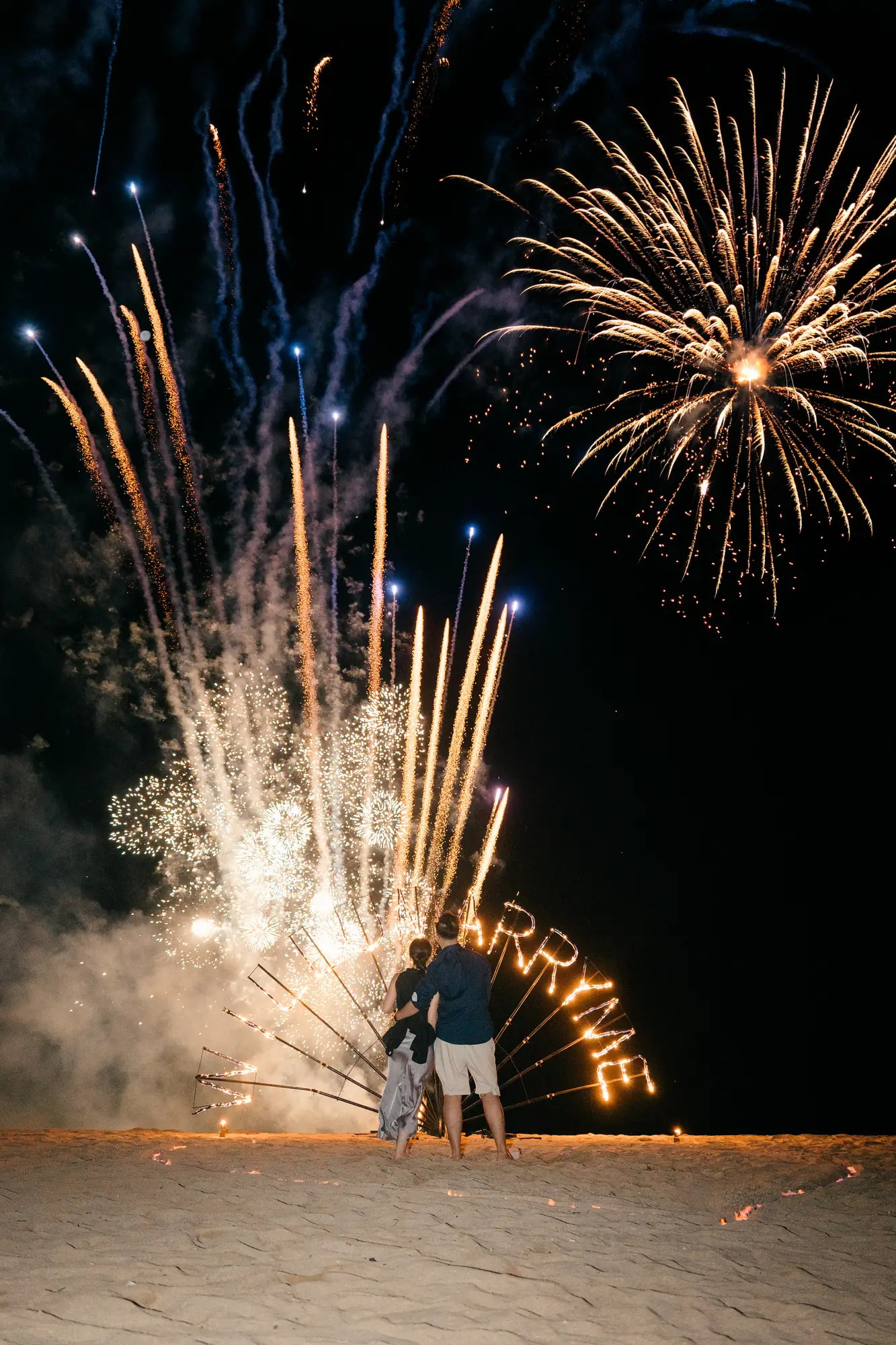 Fireworks display over the beach as a couple celebrate their Bali proposal
