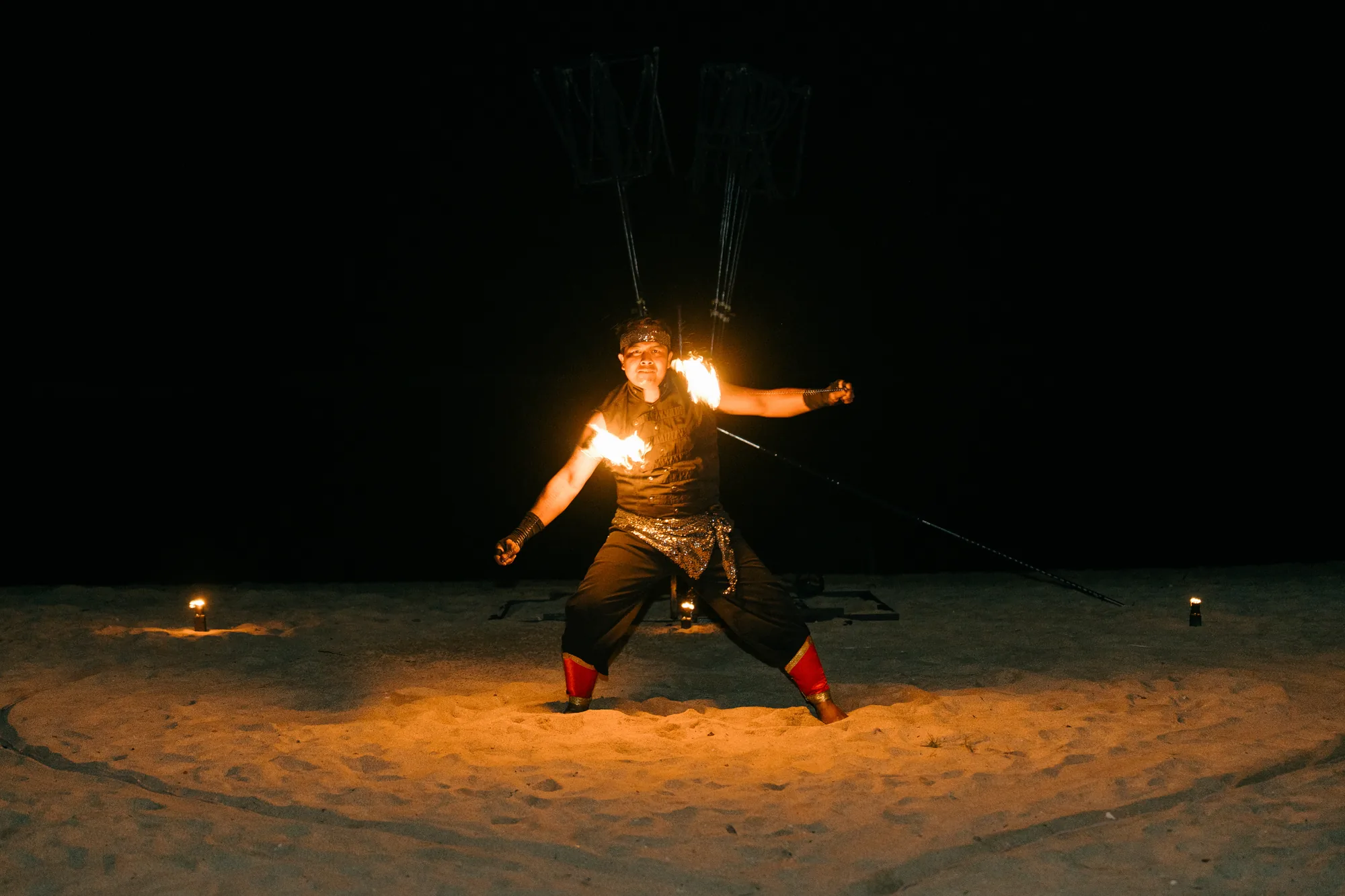 Fire dancer performing on the beach at night during a Bali proposal