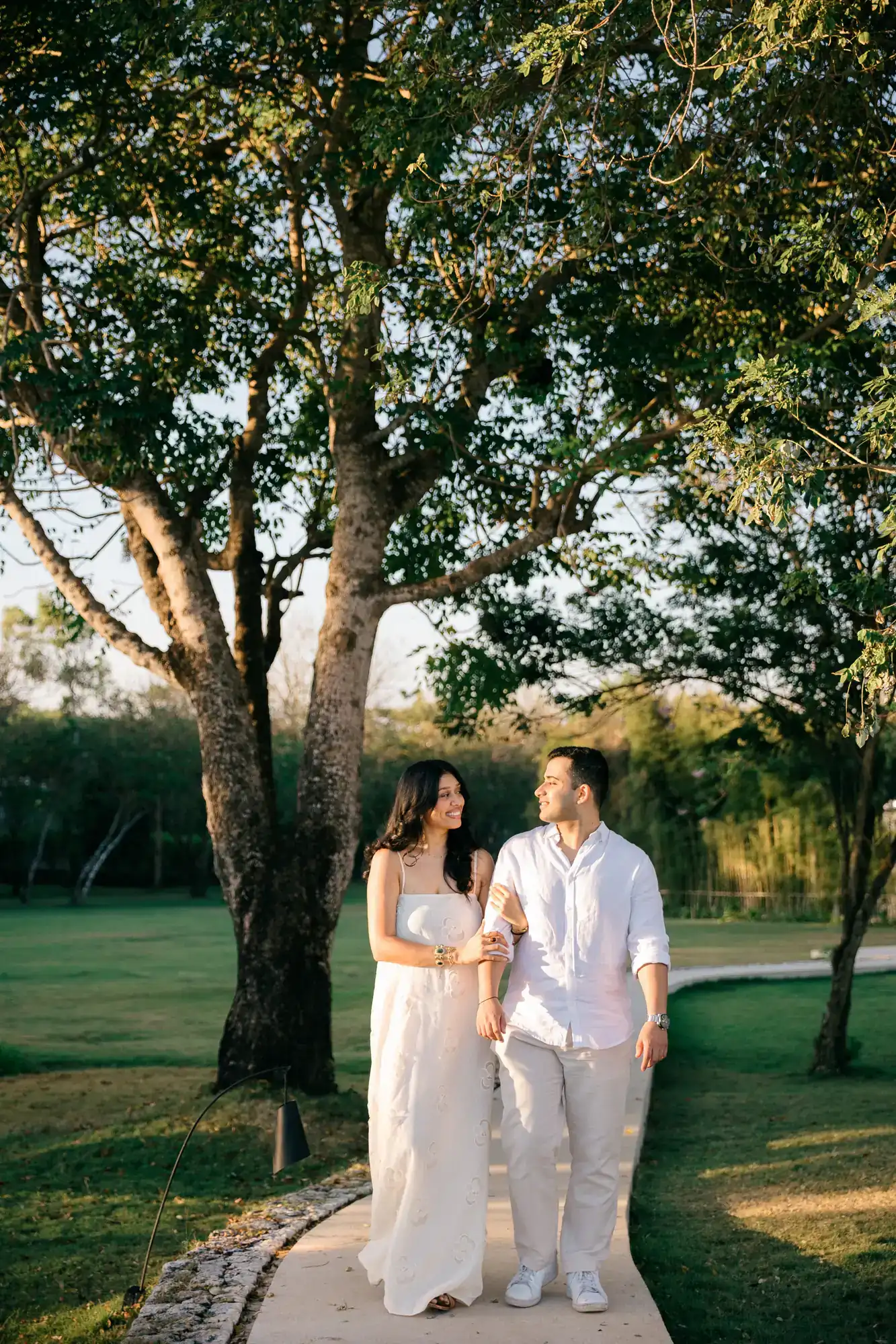Couple walking hand in hand through a garden after their Bali proposal
