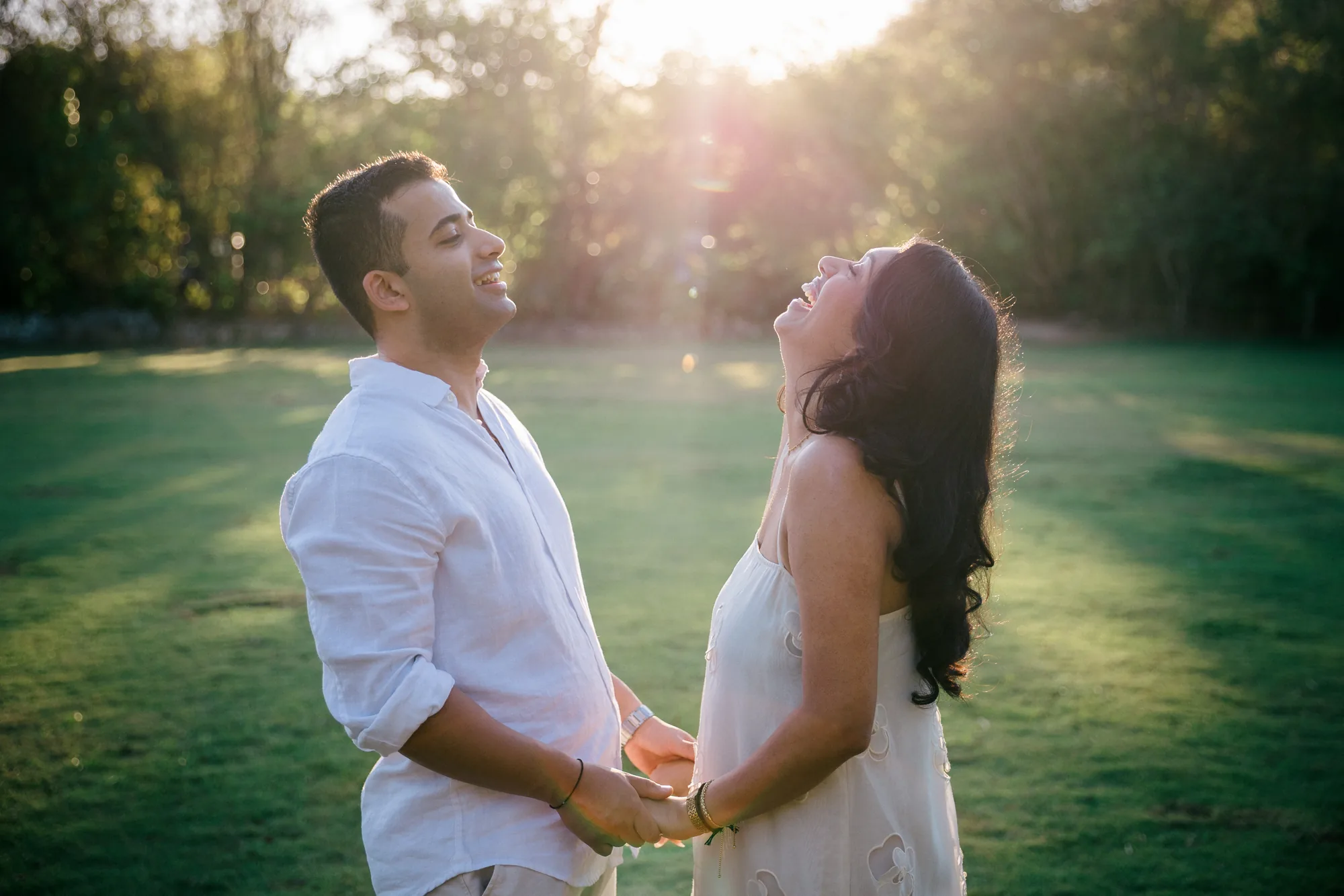 Couple holding hands in a sunlit garden after their Bali proposal
