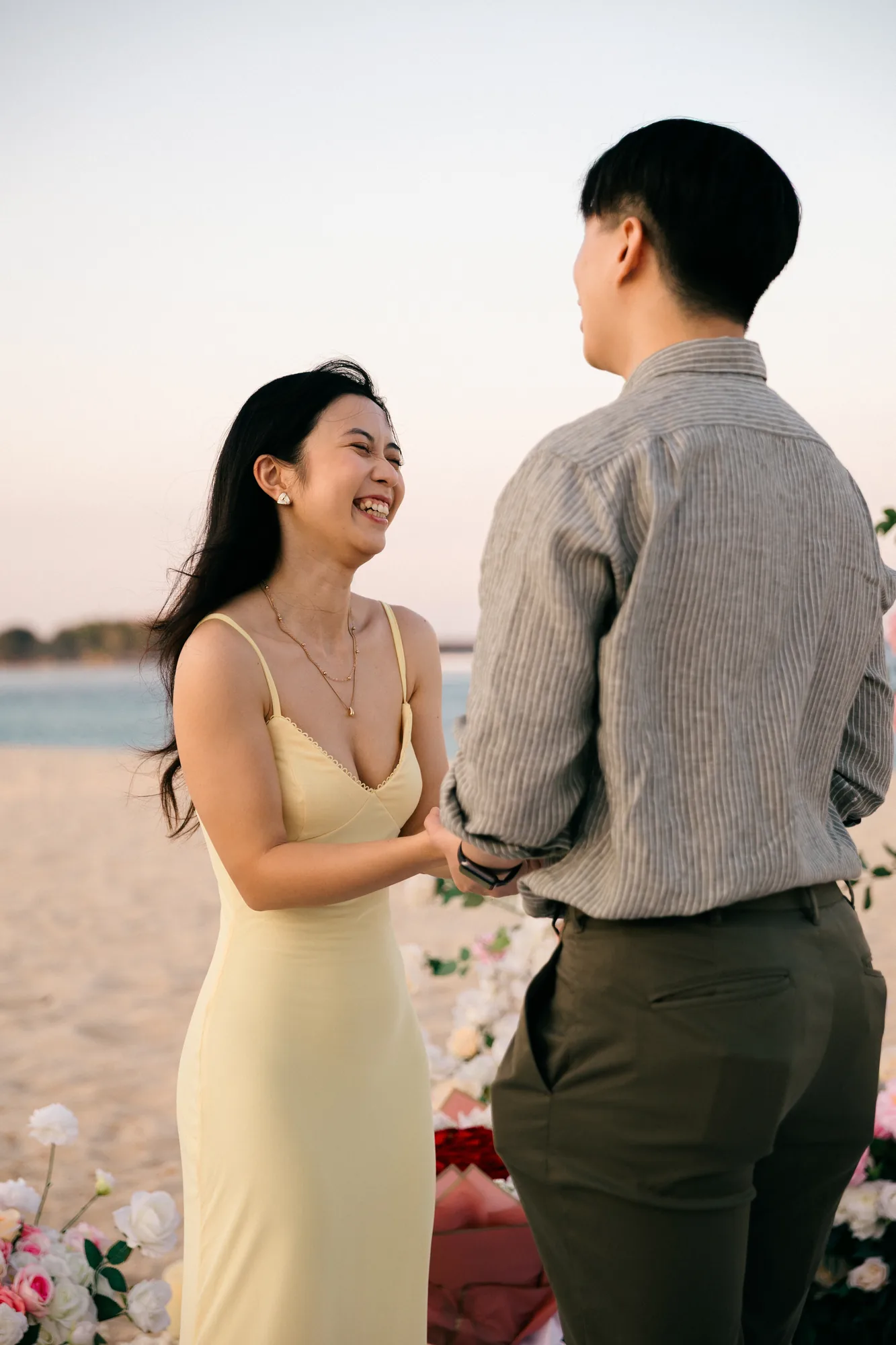 Couple smiling together on the beach at sunset during a Bali proposal