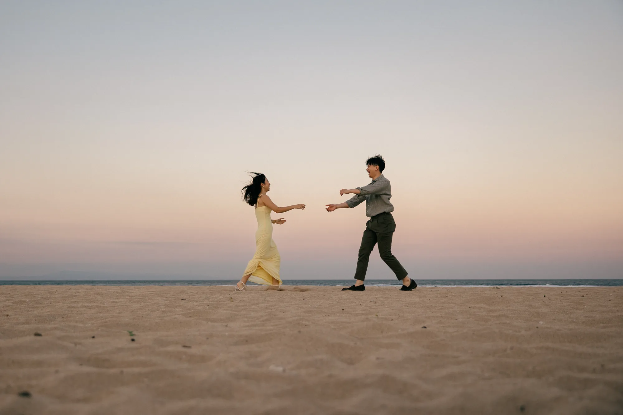 Couple running toward each other on the beach at their Bali proposal