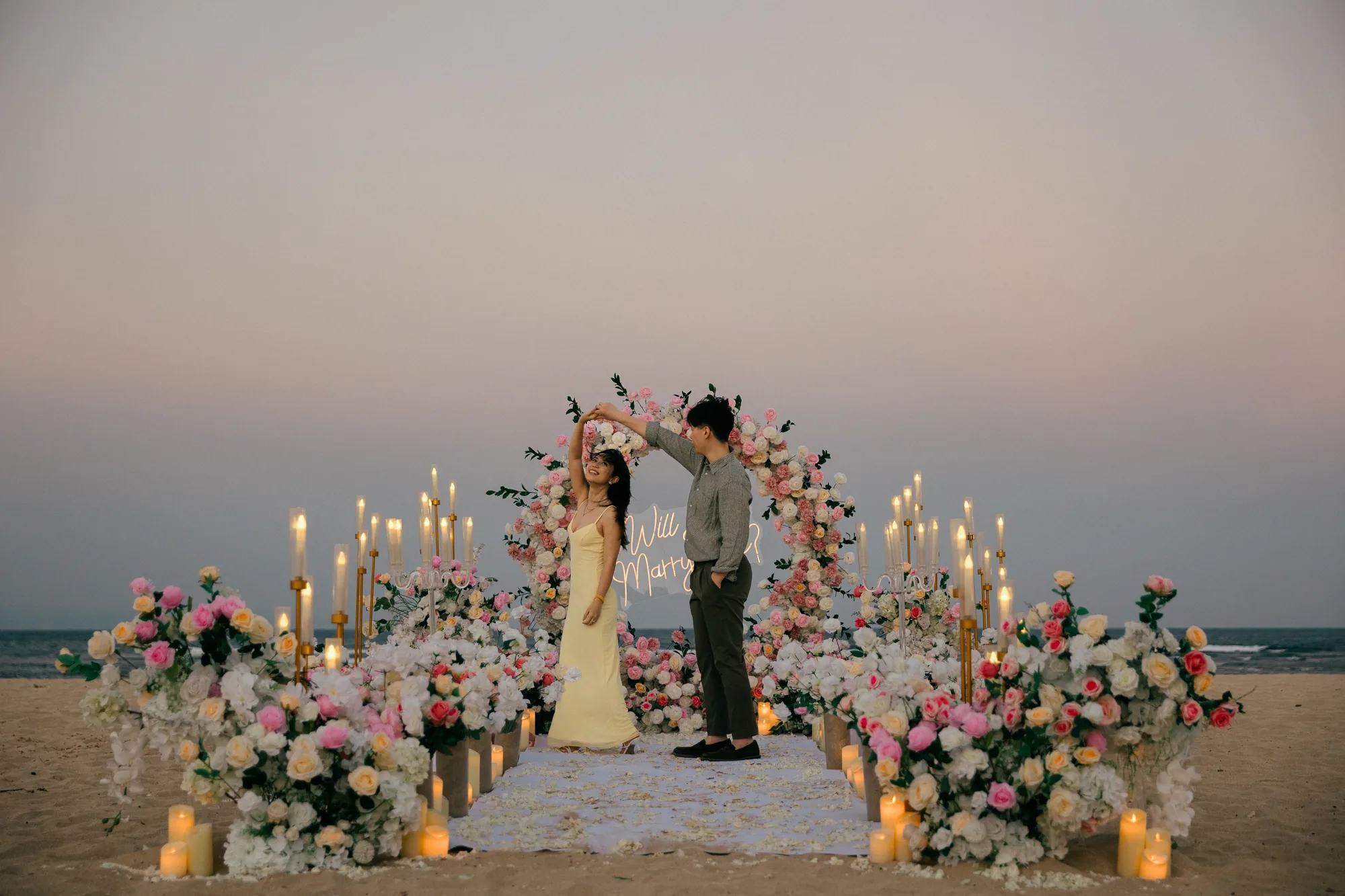 Man kneeling to propose to his partner on the beach at sunset in Bali