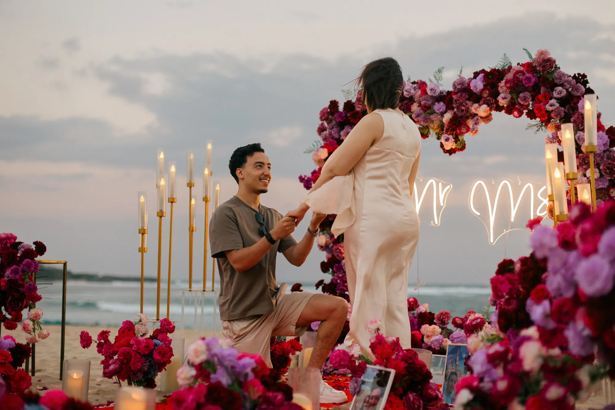 Proposal moment on a Bali beach with the ocean behind a rose heart