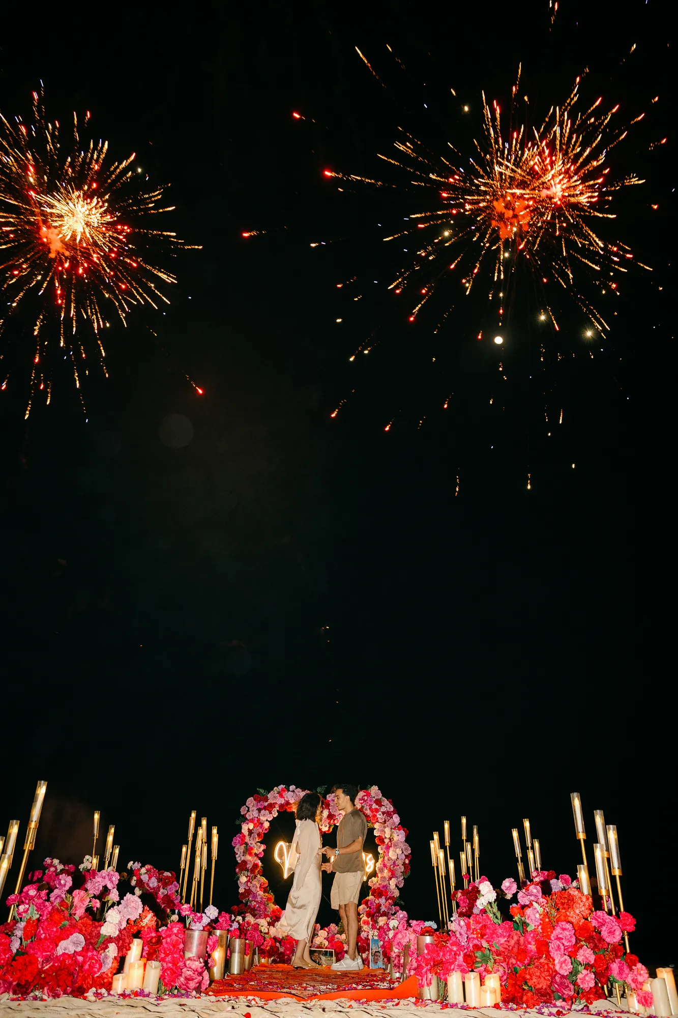 Sparklers and fireworks lighting a Bali beach proposal at night