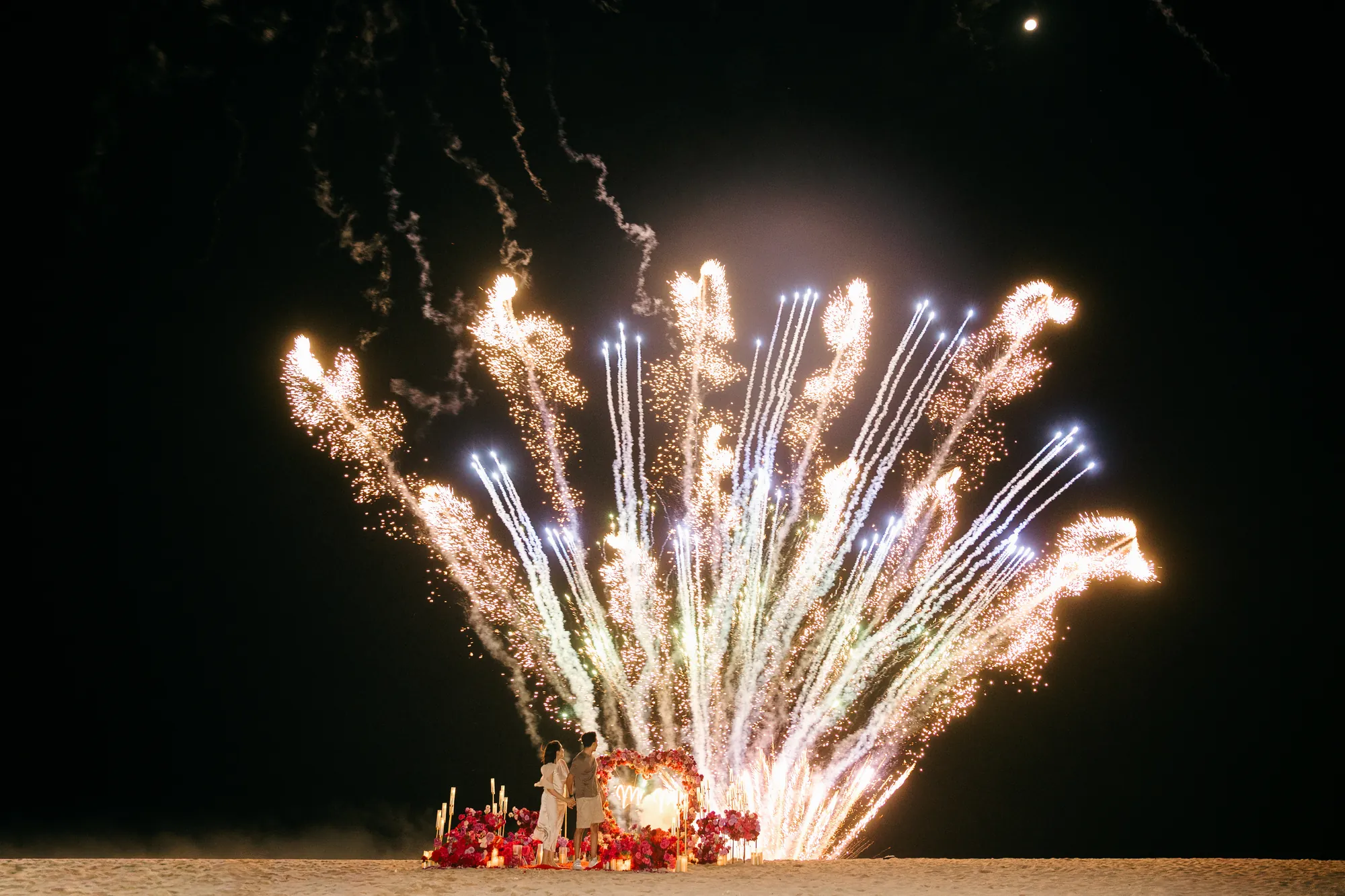 Colourful firework display over a Bali beach proposal at night